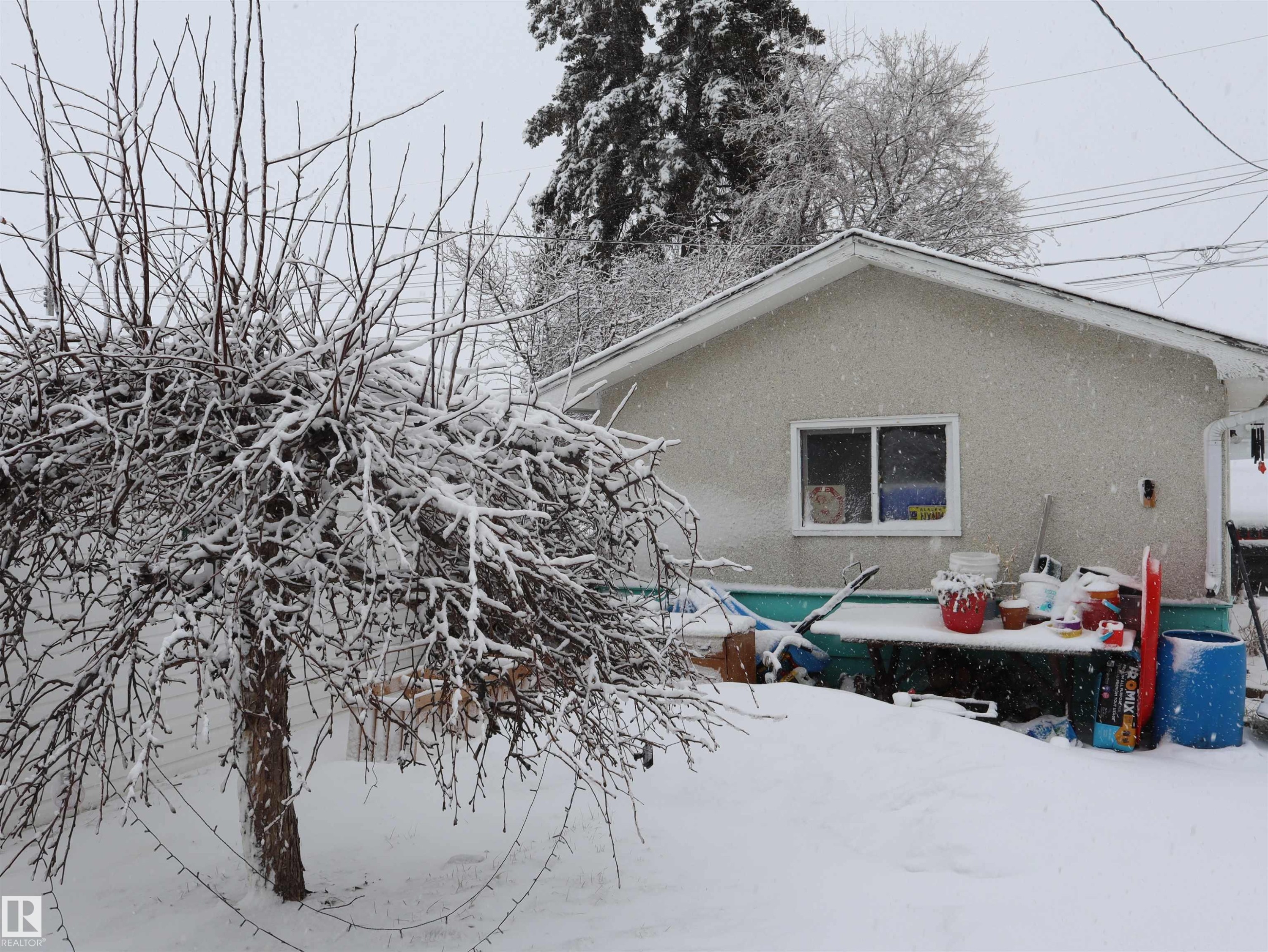 The property features a stucco exterior, a sloped roof, and a visible window - 4315 56 Avenue, Barrhead, AB - Outdoor