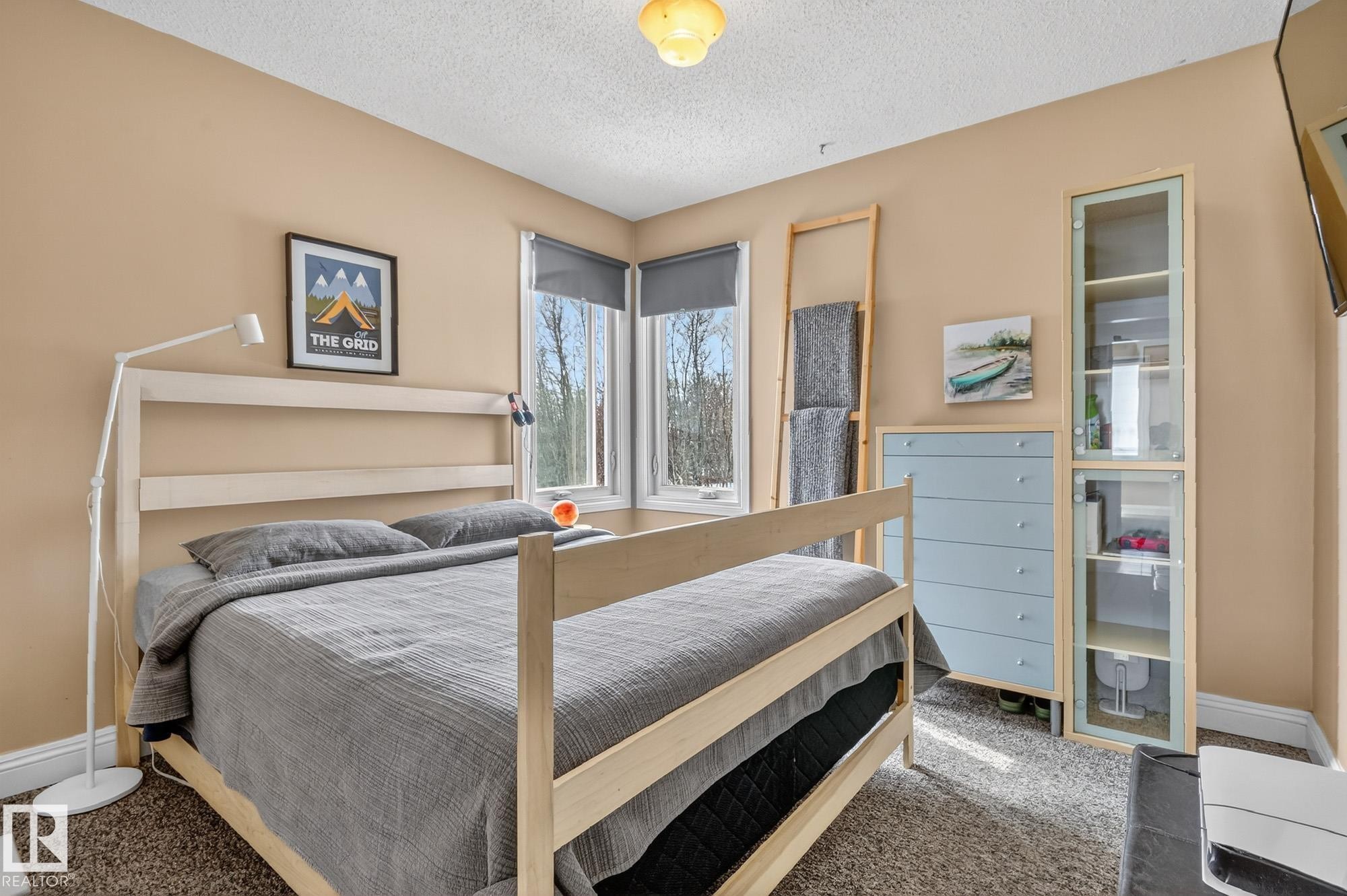 This room features neutral-toned walls, a textured carpet, and windows providing natural light - 160068 Twp 531, Rural Lamont County, AB - Indoor Photo Showing Bedroom