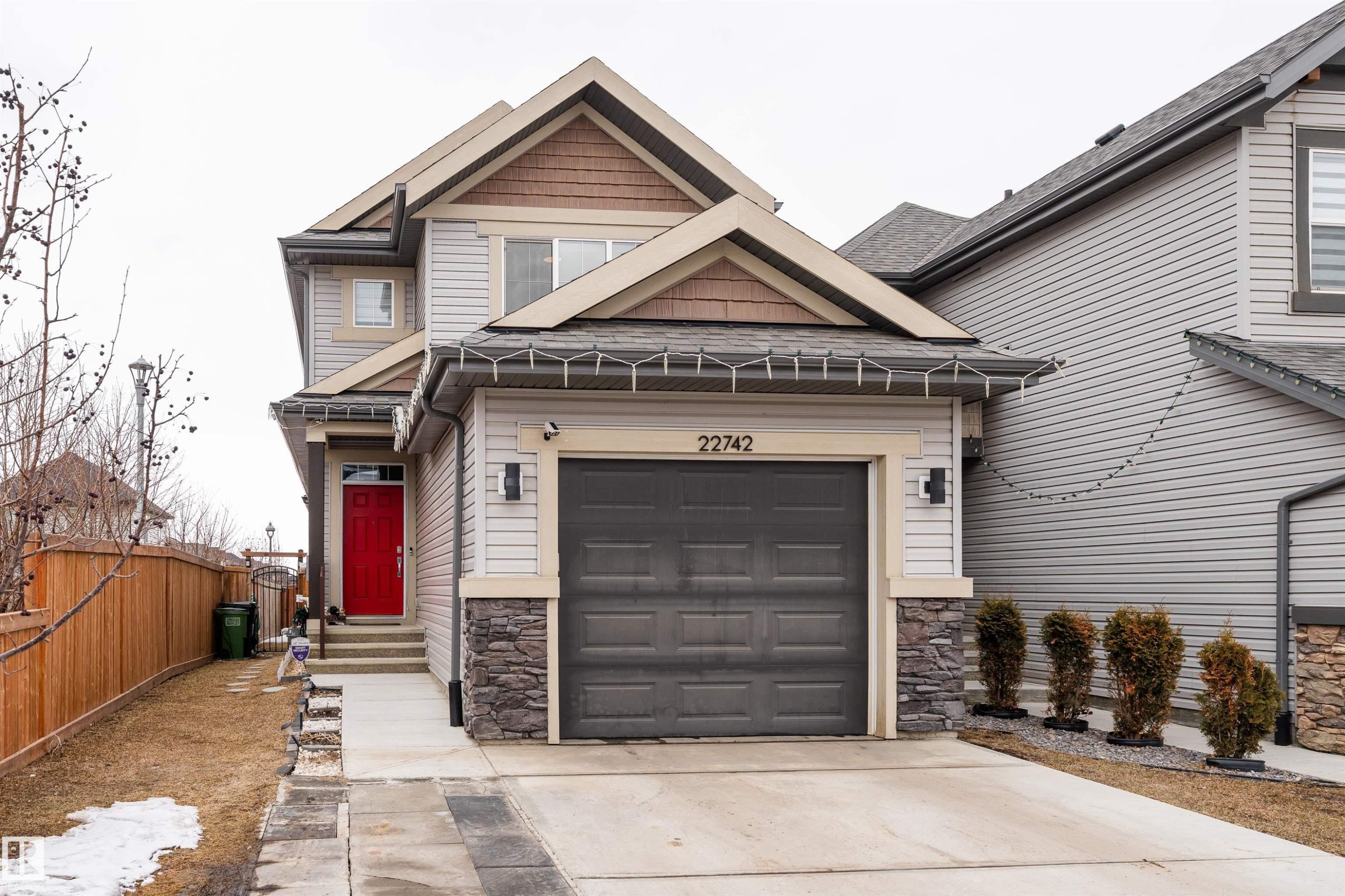 This property features a two-story exterior with light-colored siding and stone accents - 22742 95A Ave, Edmonton, AB - Outdoor