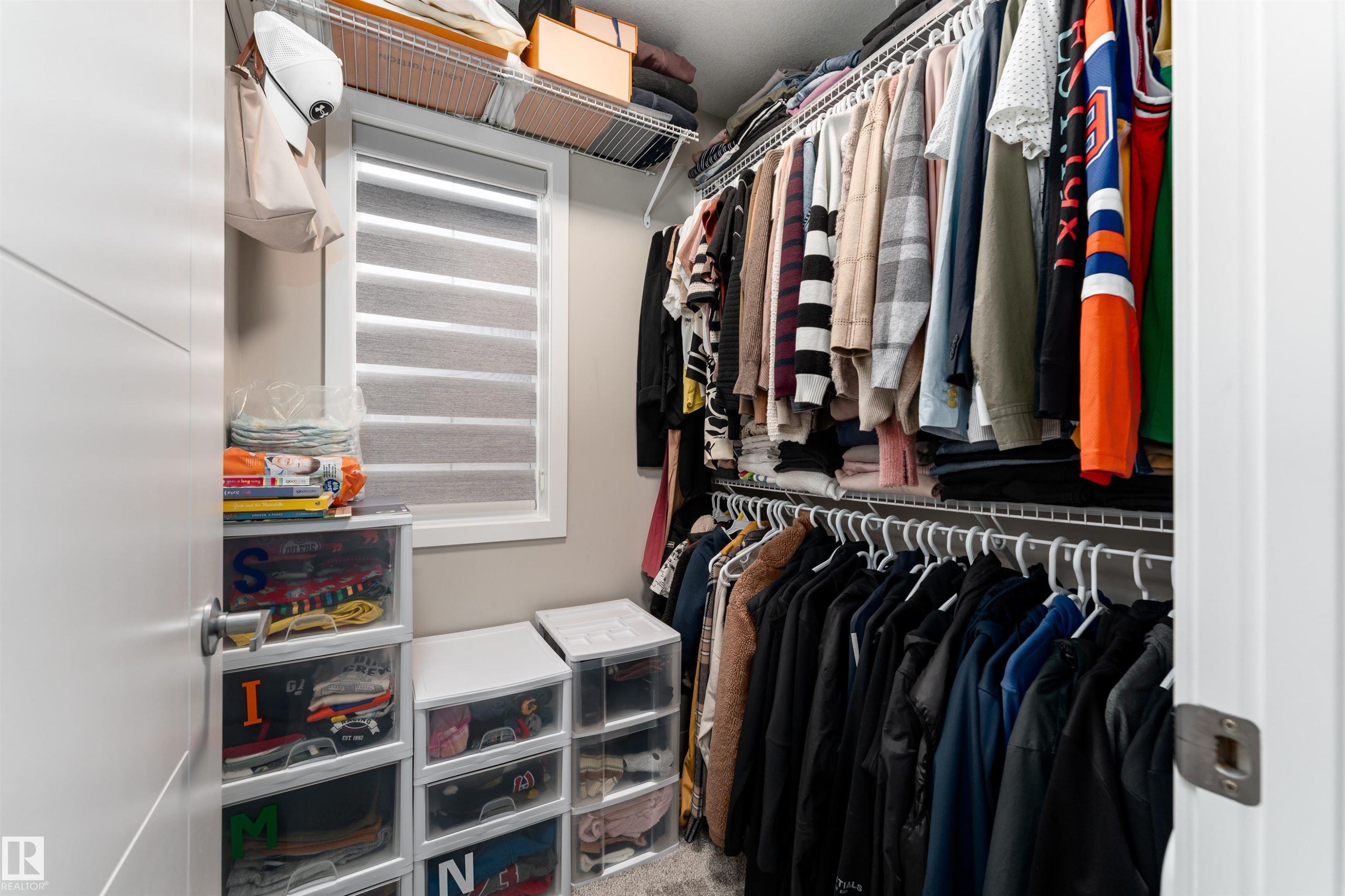 Walk-in closet featuring wire shelving, hanging rods, and a window with horizontal blinds - 22742 95A Ave, Edmonton, AB - Indoor With Storage