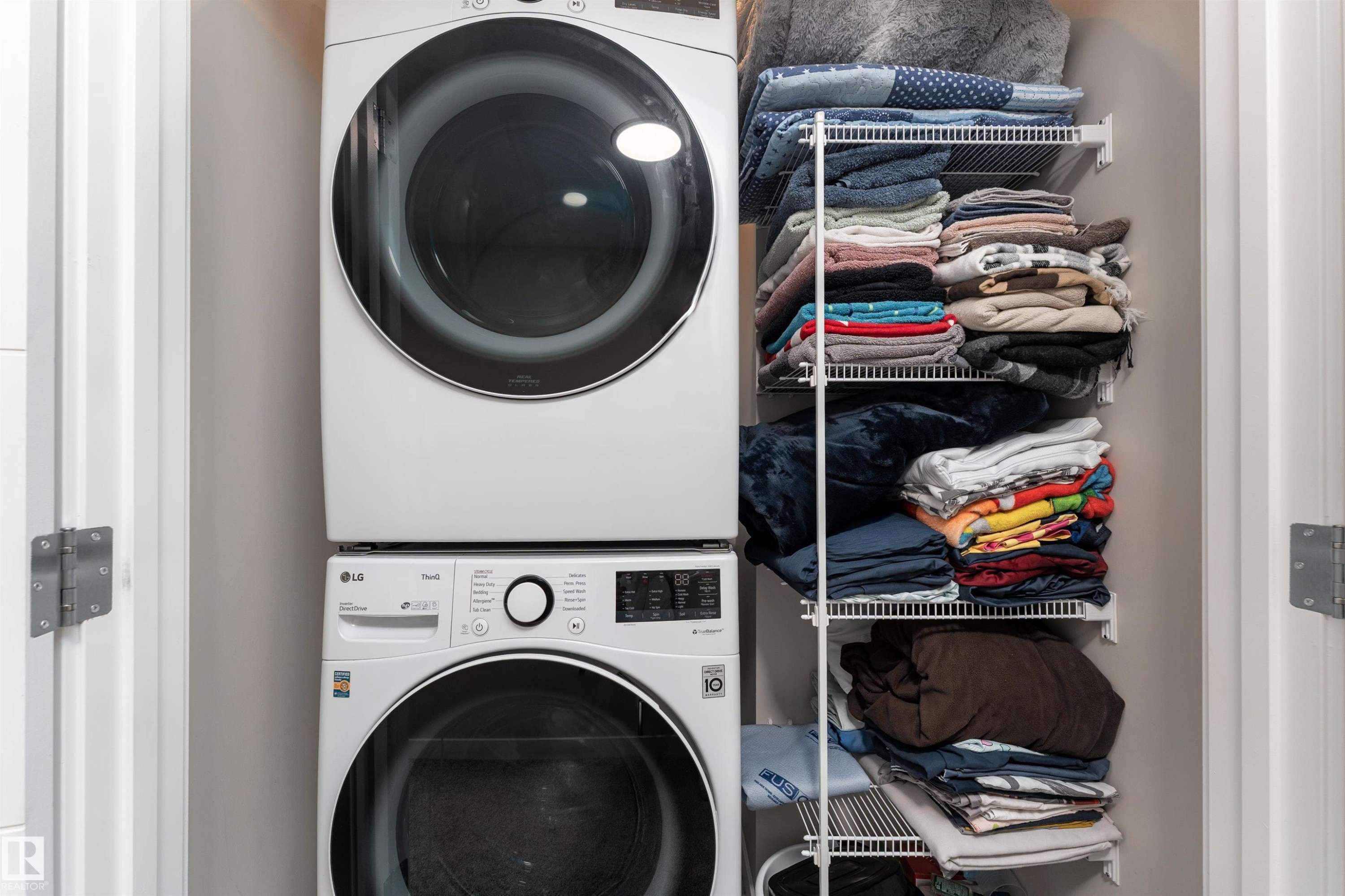 Laundry area featuring a stacked washer and dryer, and wire shelving for storage - 22742 95A Ave, Edmonton, AB - Indoor Photo Showing Laundry Room
