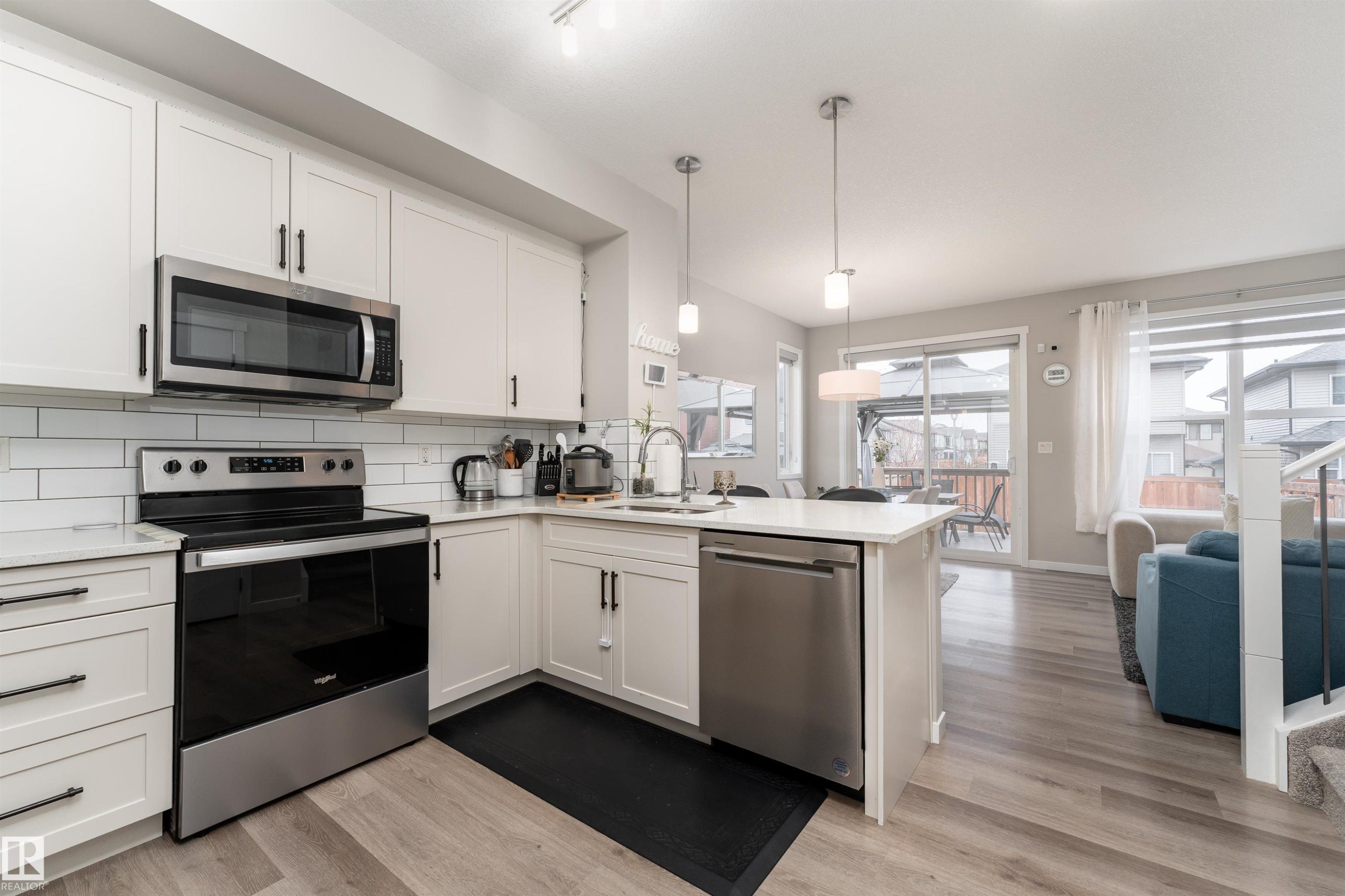 Well-appointed kitchen featuring white cabinetry, stainless steel appliances, and a subway tile backsplash - 22742 95A Ave, Edmonton, AB - Indoor Photo Showing Kitchen With Upgraded Kitchen