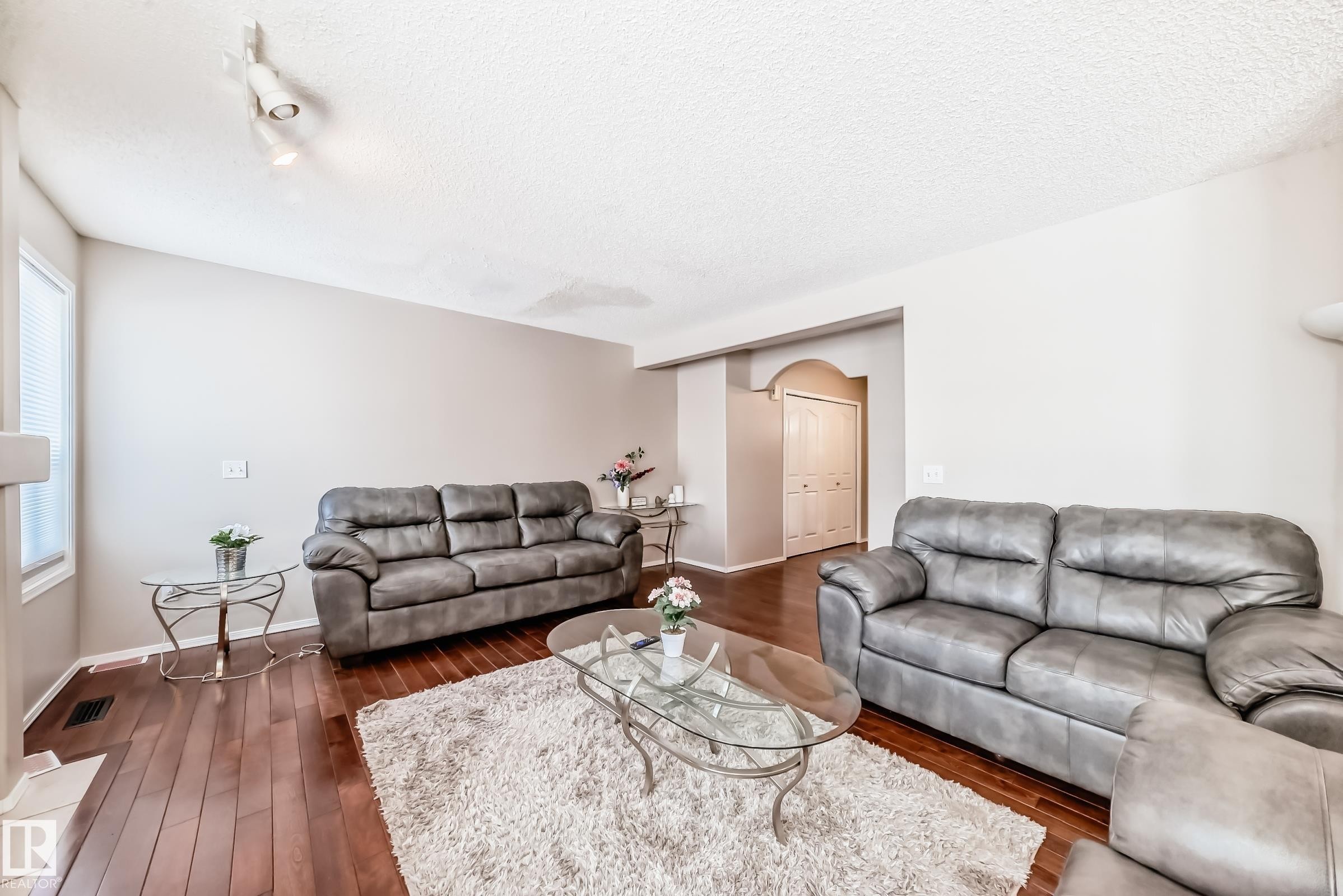 Living area featuring hardwood floors, light-colored walls, and a recessed entryway - 19024 50 Avenue, Edmonton, AB - Indoor Photo Showing Living Room