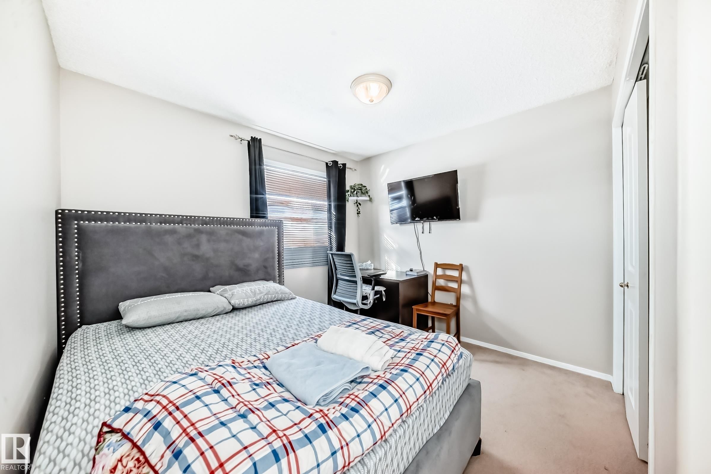 This room features light-colored walls and carpeted flooring, with a window providing natural light - 19024 50 Avenue, Edmonton, AB - Indoor Photo Showing Bedroom
