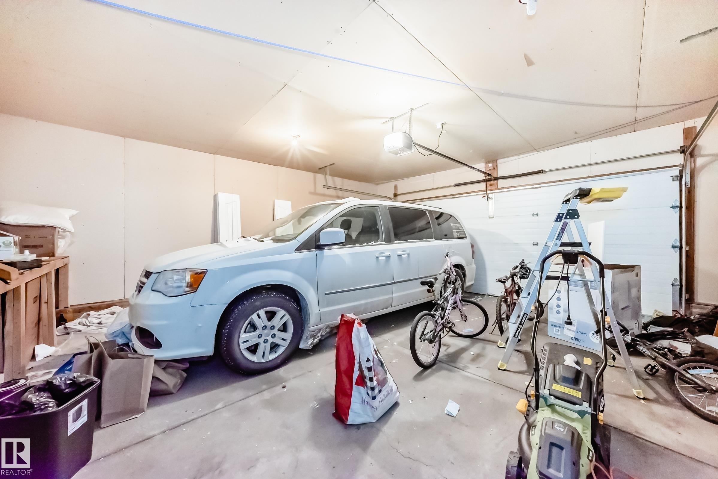 The property features a garage with a concrete floor, a garage door, and interior lighting - 19024 50 Avenue, Edmonton, AB - Indoor Photo Showing Garage