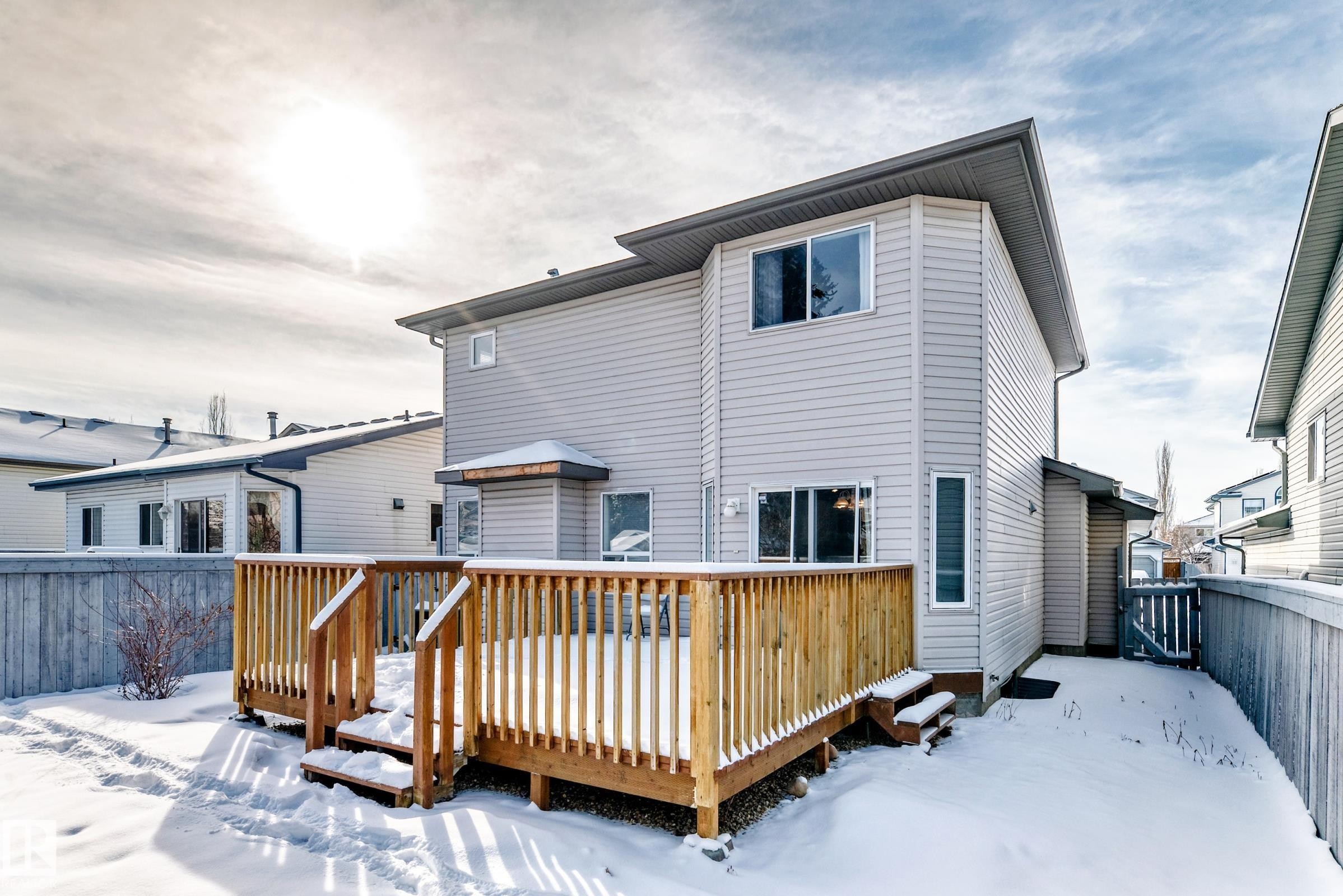 The property features a wooden deck with railing, sliding glass patio doors, and a fenced yard - 19024 50 Avenue, Edmonton, AB - Outdoor With Exterior
