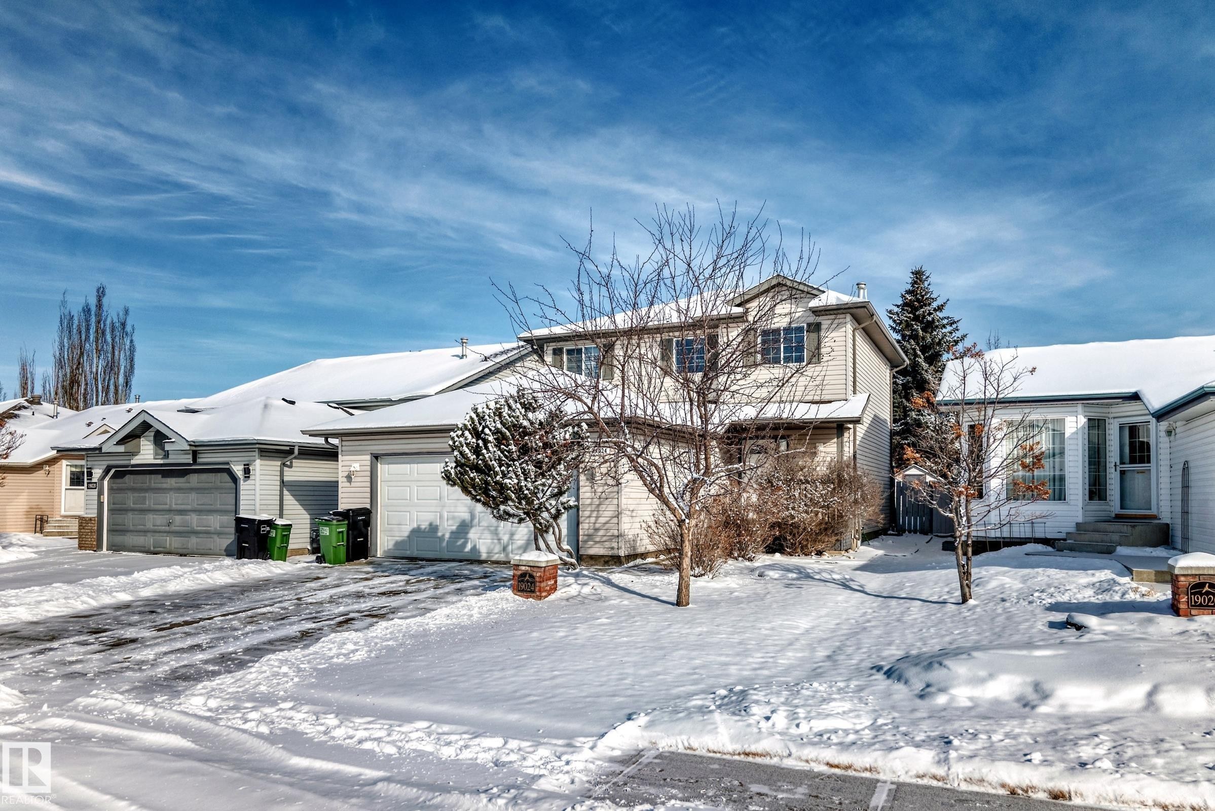 The property features a two-story residence with a light-colored exterior and a snow-covered roof - 19024 50 Avenue, Edmonton, AB - Outdoor
