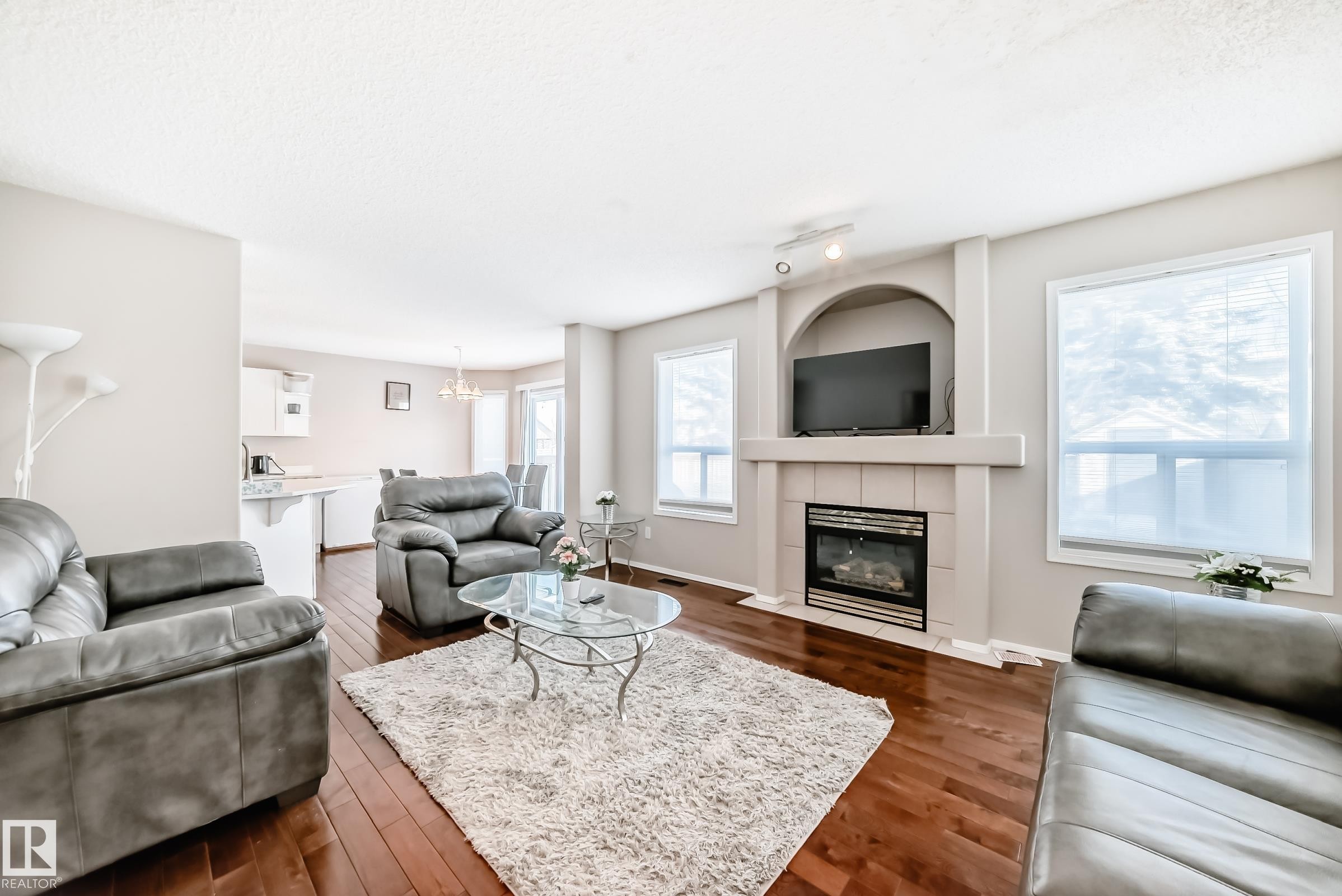 The living area features hardwood floors and a fireplace with a mantel - 19024 50 Avenue, Edmonton, AB - Indoor Photo Showing Living Room With Fireplace