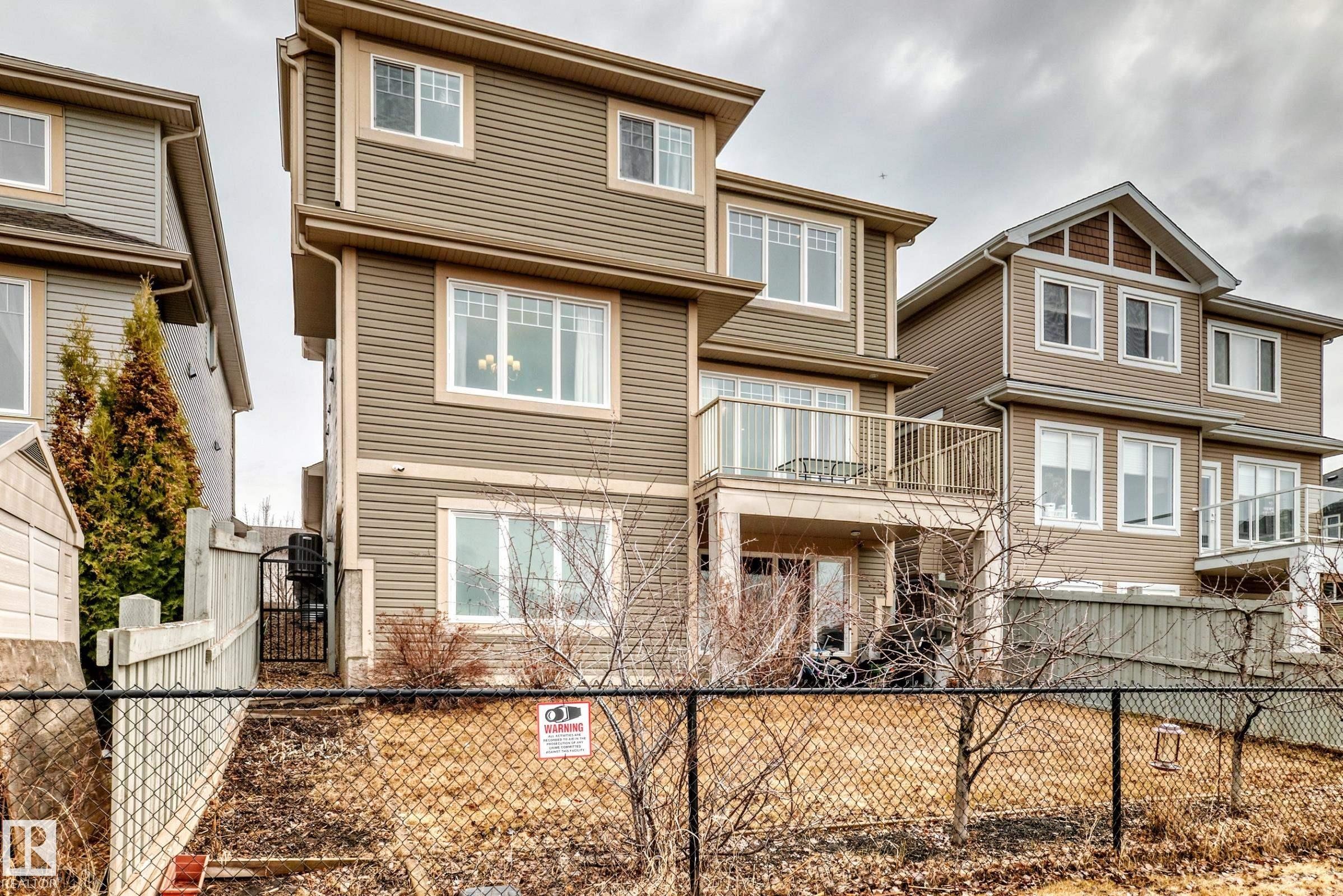 The property features a multi-story exterior with horizontal siding and white-framed windows - 4134 Charles Link, Edmonton, AB - Outdoor With Deck Patio Veranda With Facade