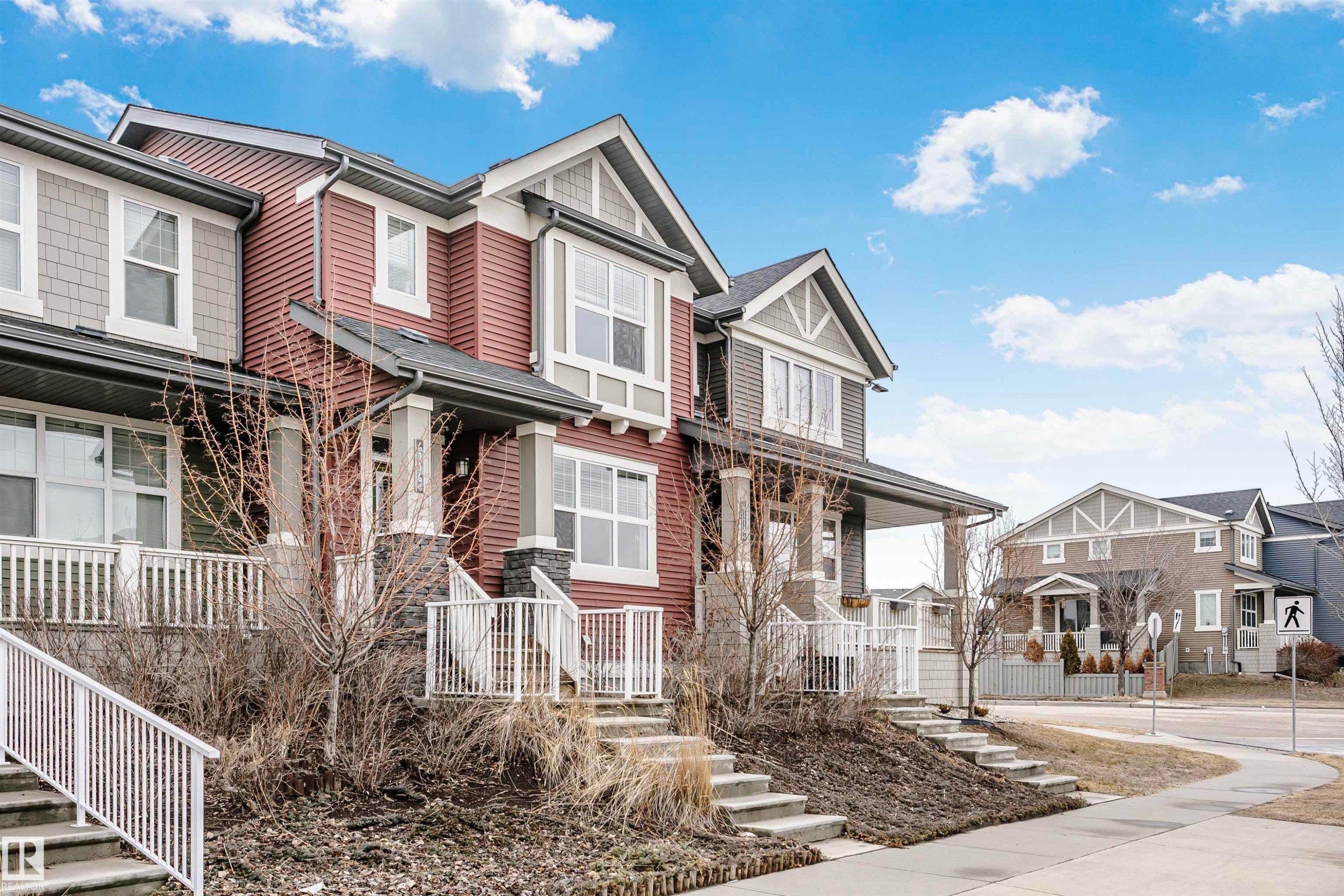The property features a red and grey exterior with white trim, multiple windows, and a covered porch - 6116 Rosenthal Way, Edmonton, AB - Outdoor With Facade