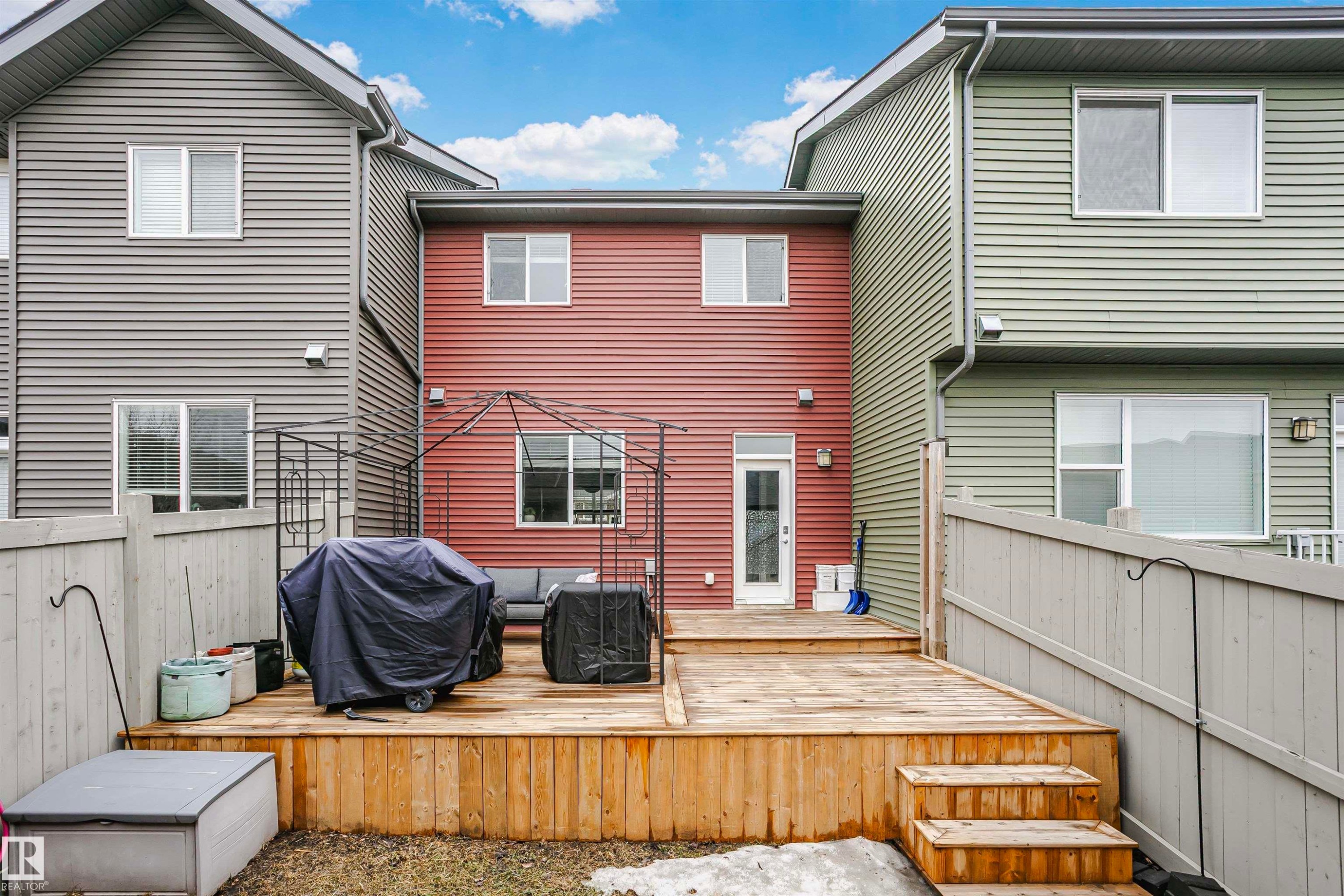The property features an extensive wooden deck with stairs leading to the yard - 6116 Rosenthal Way, Edmonton, AB - Outdoor With Deck Patio Veranda With Exterior