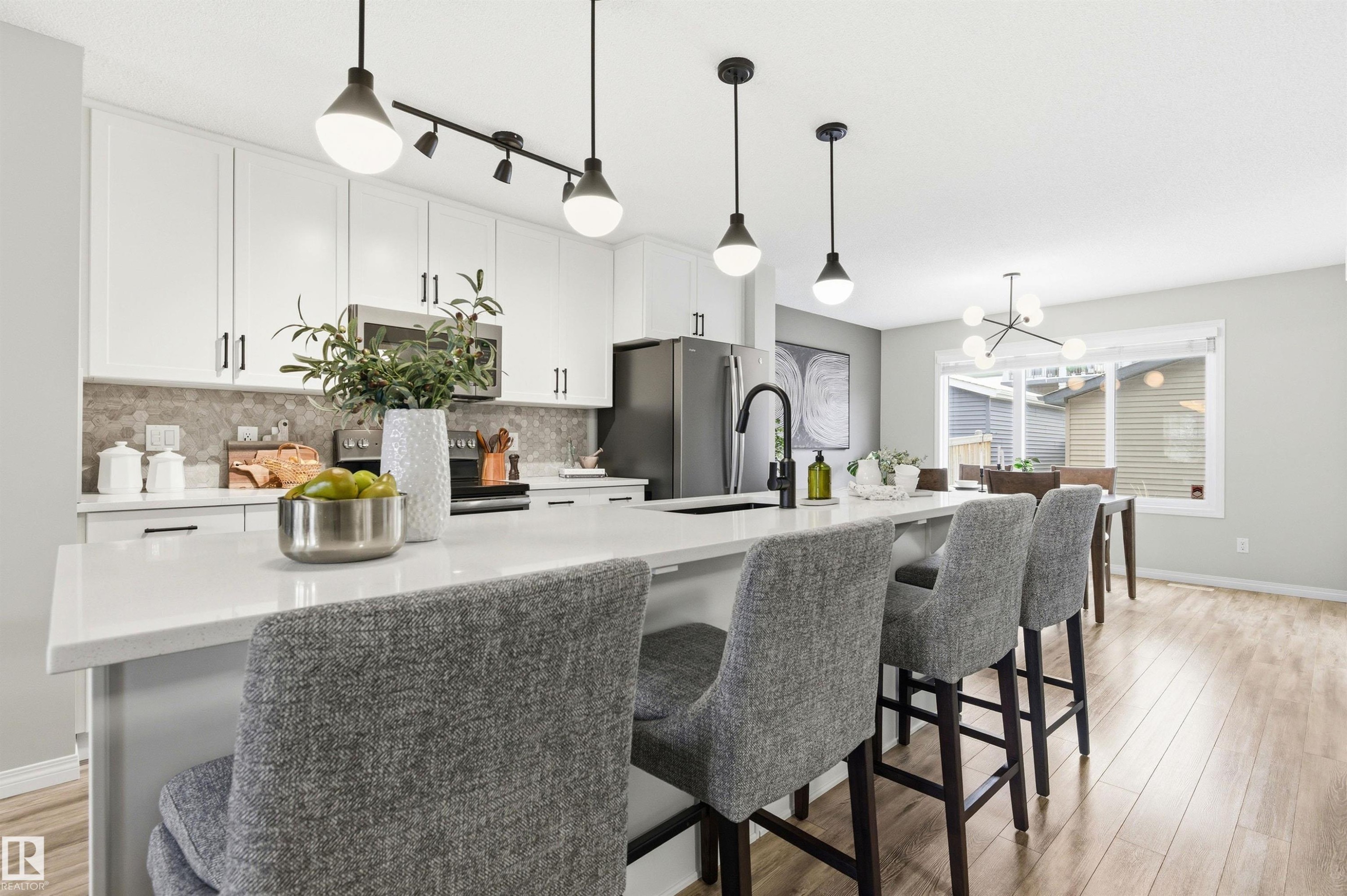 The kitchen features white cabinetry, a light-colored countertop, and a tiled backsplash - 3247 Cherry Crescent, Edmonton, AB - Indoor