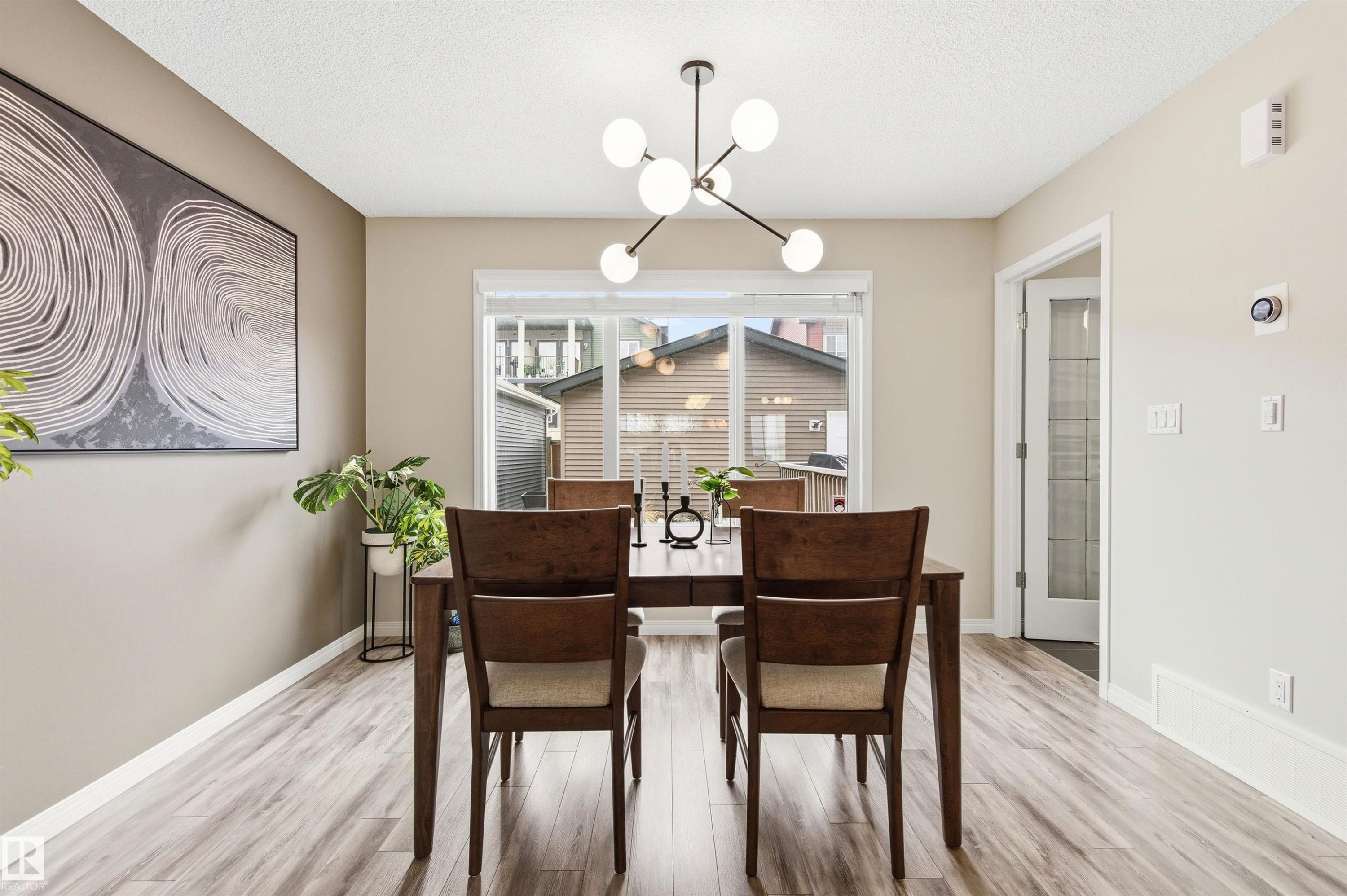 The dining area features light-toned walls, wood-look flooring, and a modern light fixture - 3247 Cherry Crescent, Edmonton, AB - Indoor Photo Showing Dining Room