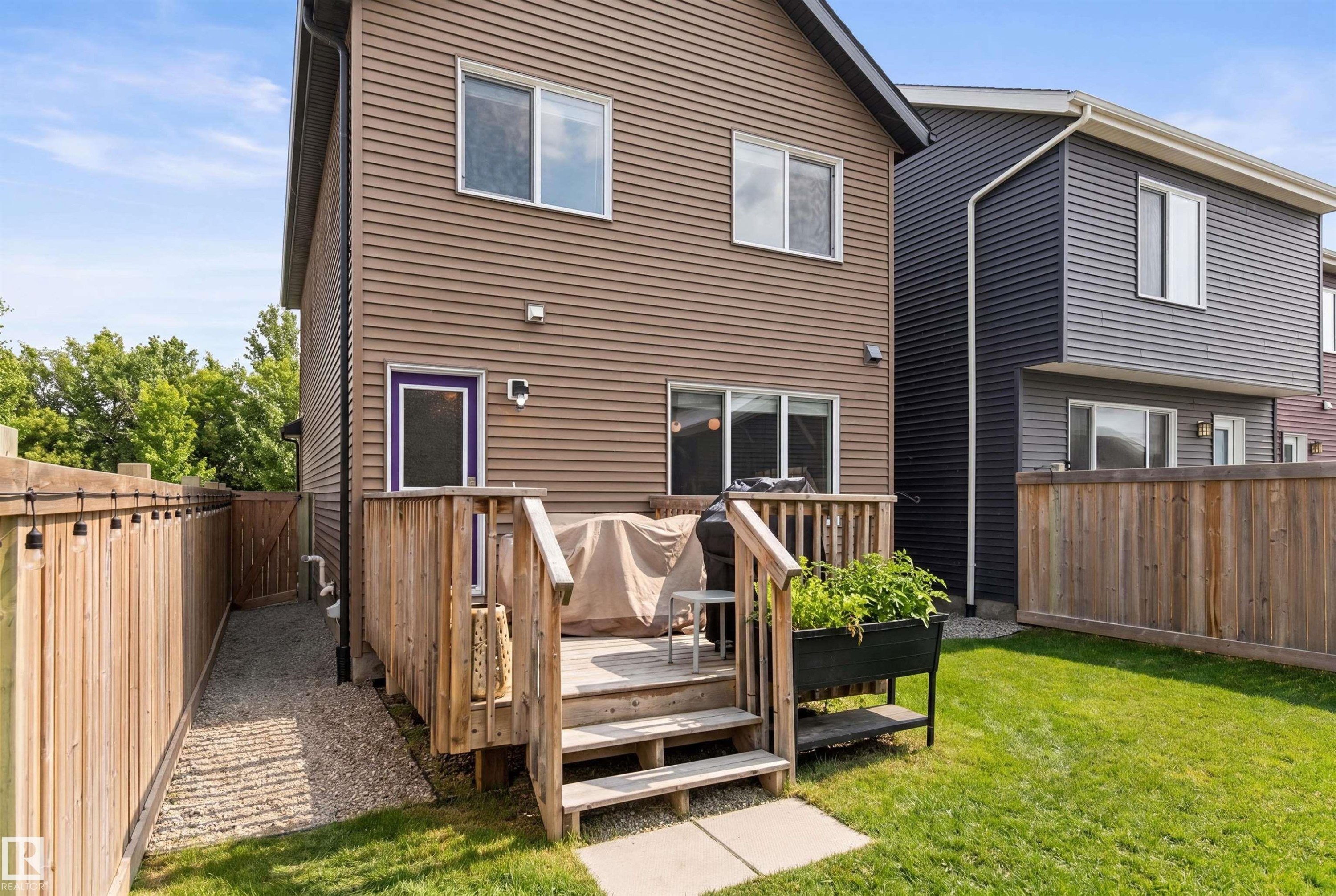 The property features an exterior with brown siding, a wooden deck, and a fenced yard with a grass lawn - 3247 Cherry Crescent, Edmonton, AB - Outdoor With Exterior