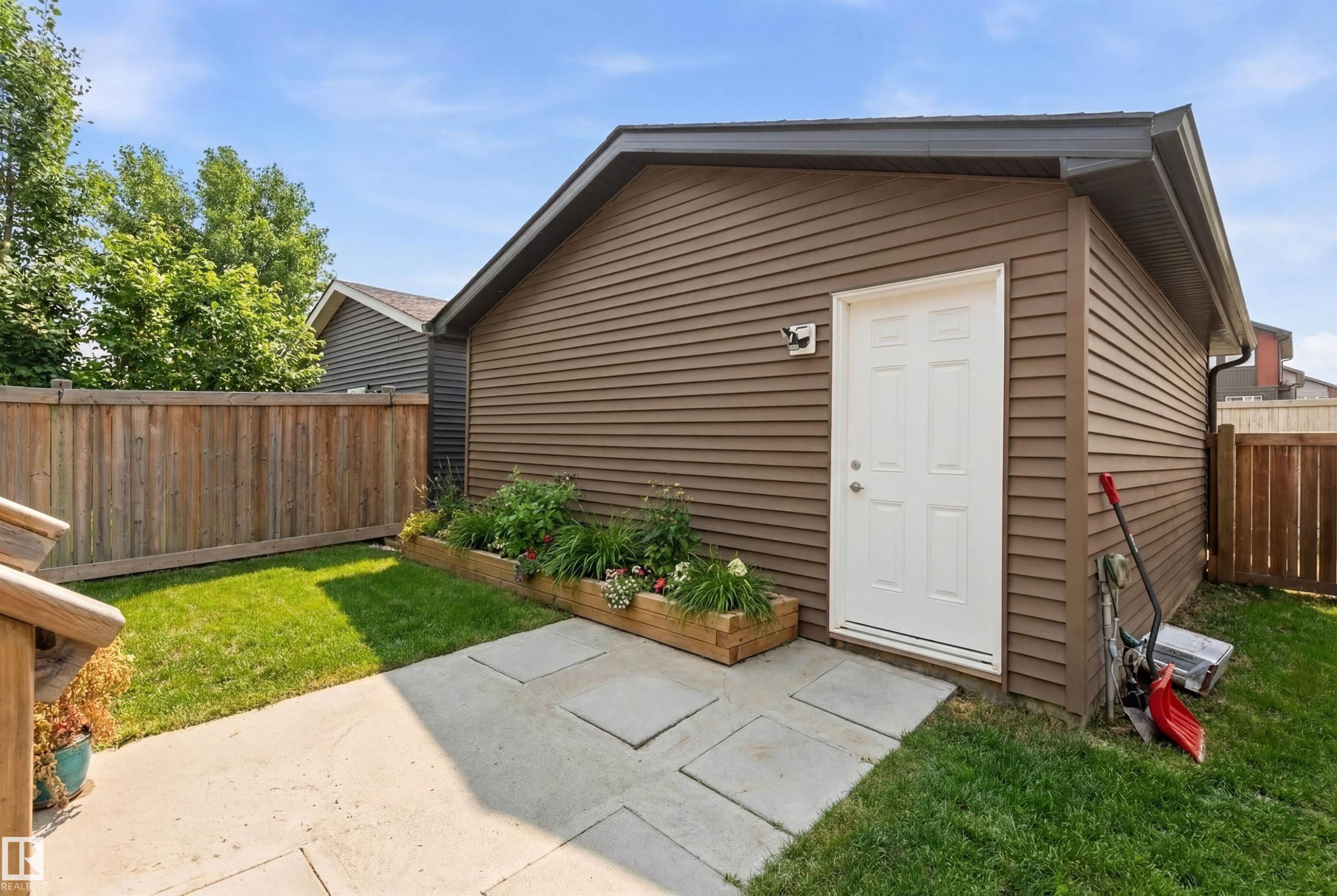 The property includes a spacious backyard with a lawn area, a wooden fence, and a garden bed - 3247 Cherry Crescent, Edmonton, AB - Outdoor