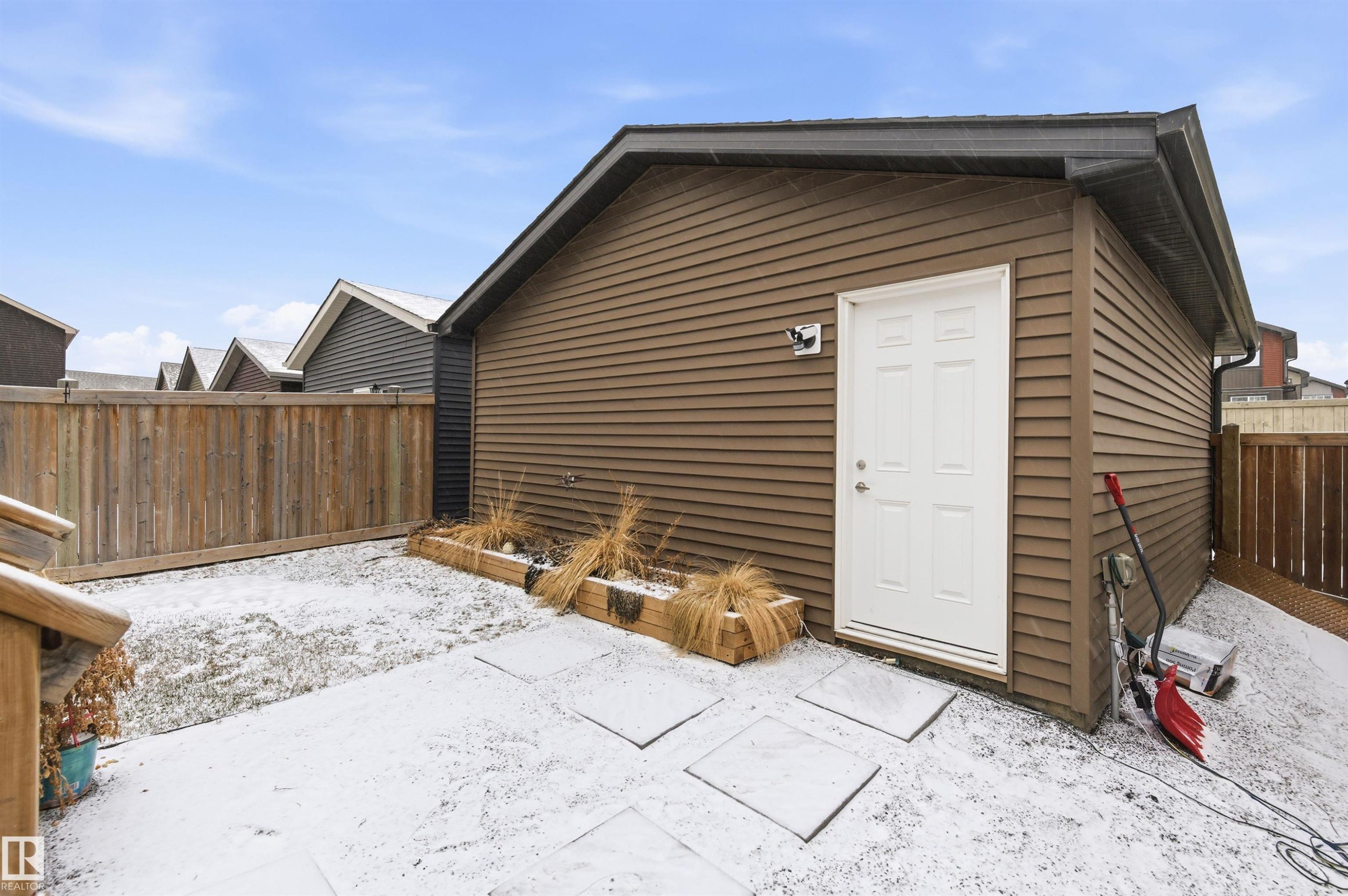 The property features a detached exterior structure with brown siding, a white door, and a dark roof - 3247 Cherry Crescent, Edmonton, AB - Outdoor With Exterior