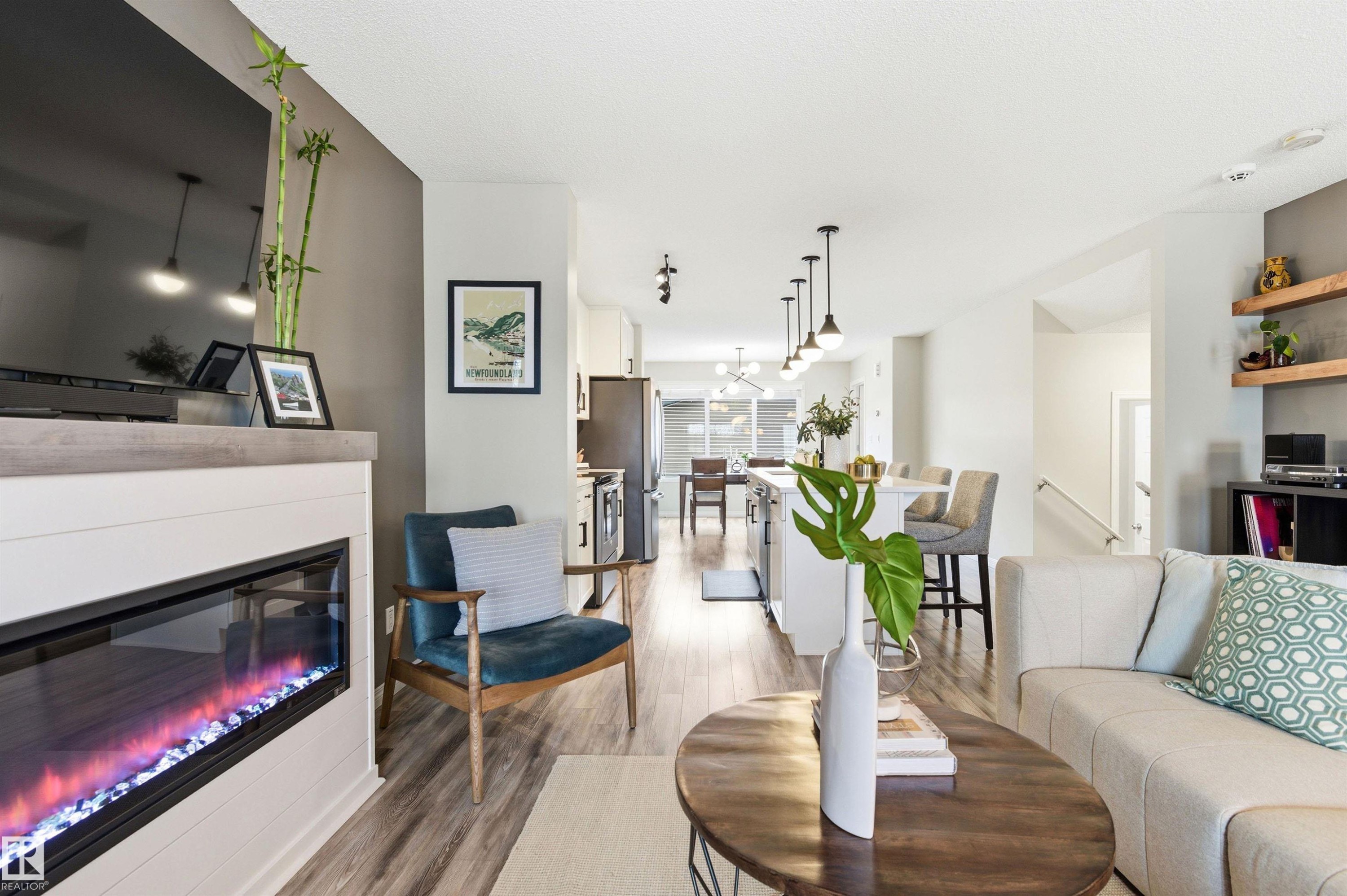 The main living space features an electric fireplace, hardwood style floors, and an open concept layout - 3247 Cherry Crescent, Edmonton, AB - Indoor Photo Showing Living Room With Fireplace