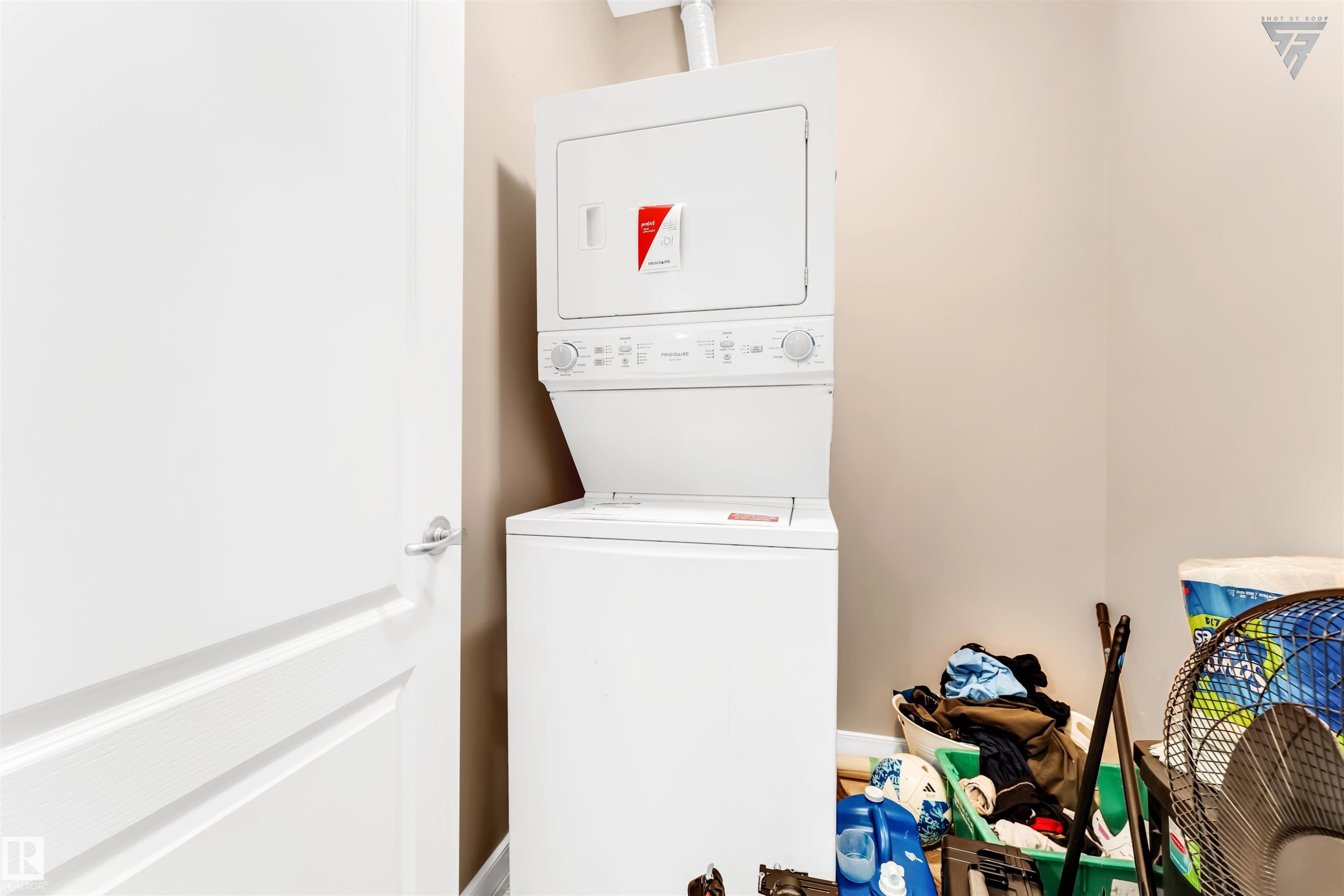 Laundry area featuring a stacked white washer and dryer unit - #418 392 Silver Berry Road Nw, Edmonton, AB - Indoor Photo Showing Laundry Room