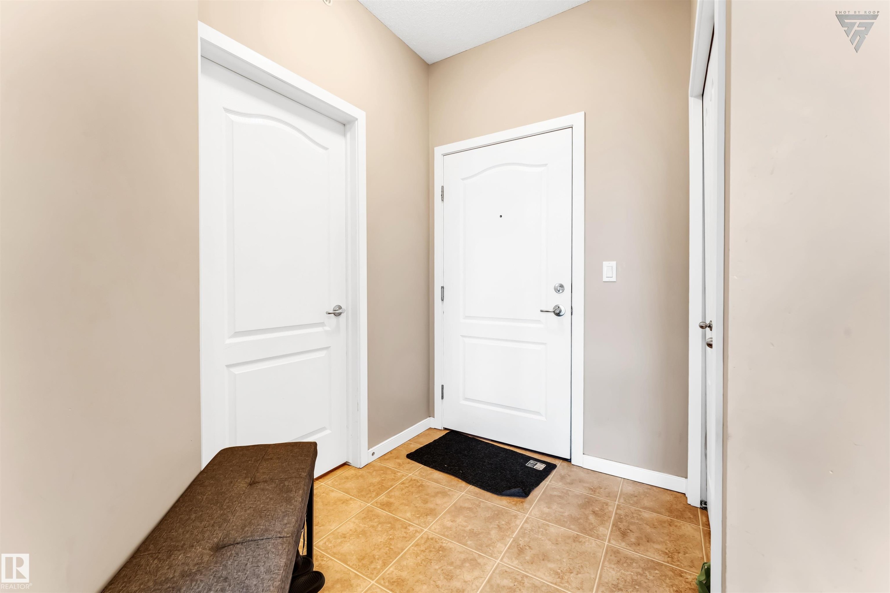 Entryway featuring neutral-toned walls, tile flooring, and white interior doors - #418 392 Silver Berry Road Nw, Edmonton, AB - Indoor Photo Showing Other Room