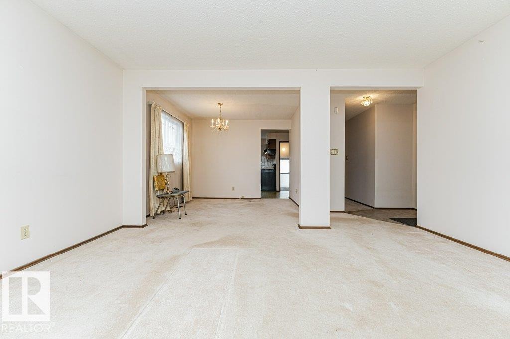 Spacious interior featuring light-toned carpeting and white walls - 8804 19 Avenue, Edmonton, AB - Indoor Photo Showing Other Room