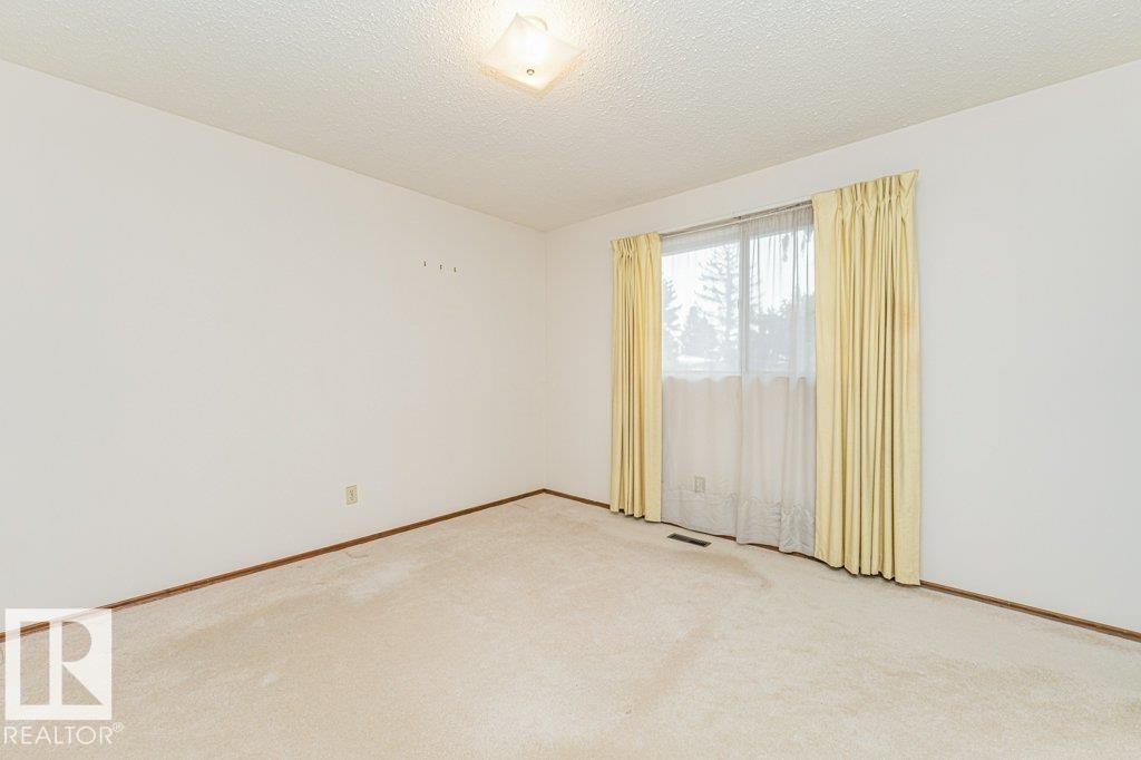 This room features a window with curtains, carpeted flooring, and a ceiling light fixture - 8804 19 Avenue, Edmonton, AB - Indoor Photo Showing Other Room