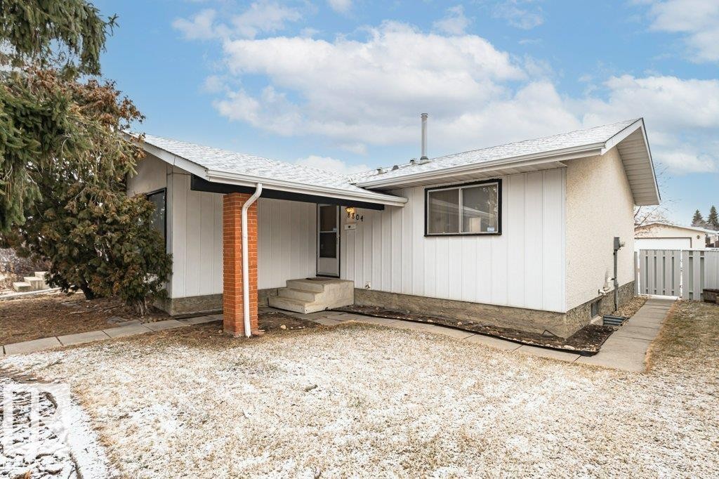 The property features white exterior siding, a light-colored roof, and a front entry with brick accents - 8804 19 Avenue, Edmonton, AB - Outdoor