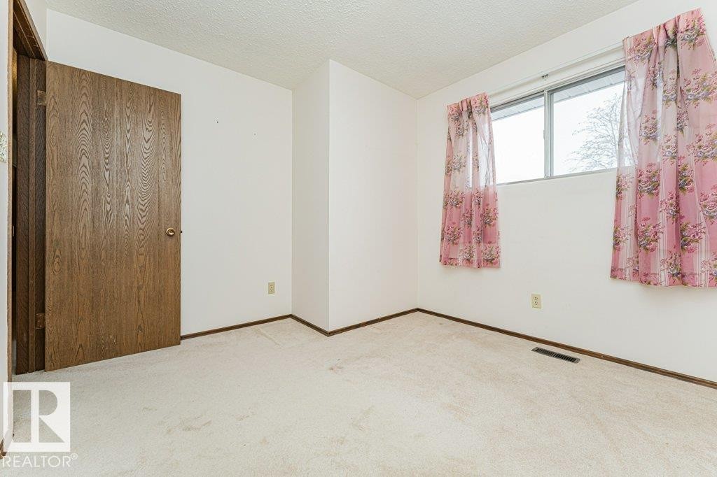 This room features neutral-toned carpeting, white walls, and a window providing natural light - 8804 19 Avenue, Edmonton, AB - Indoor Photo Showing Other Room
