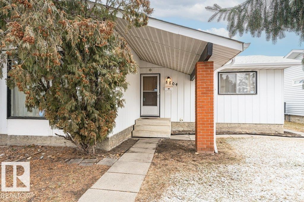 The property features a white exterior with vertical siding and a visible address number - 8804 19 Avenue, Edmonton, AB - Outdoor