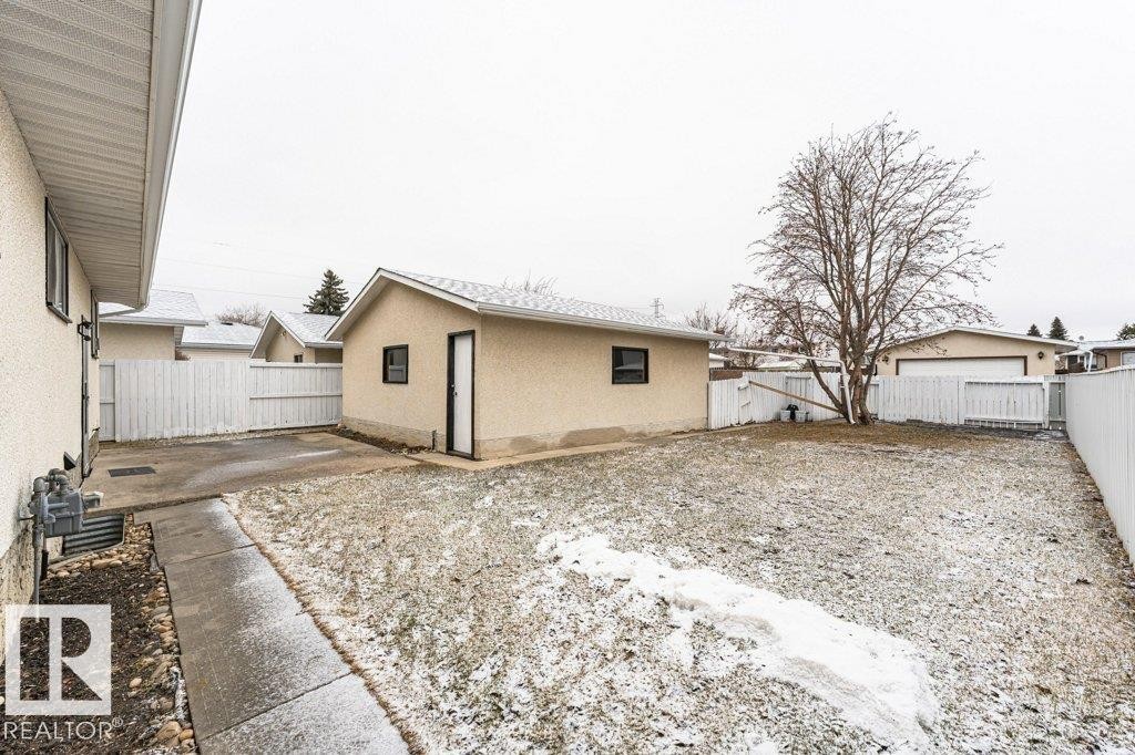 The property features a detached building with a door and window, a paved pathway, and a bare tree - 8804 19 Avenue, Edmonton, AB - Outdoor