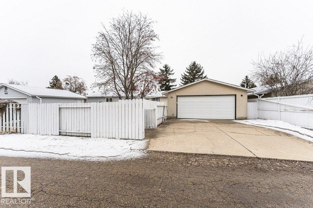 Detached garage with a driveway and a white fence - 8804 19 Avenue, Edmonton, AB - Outdoor
