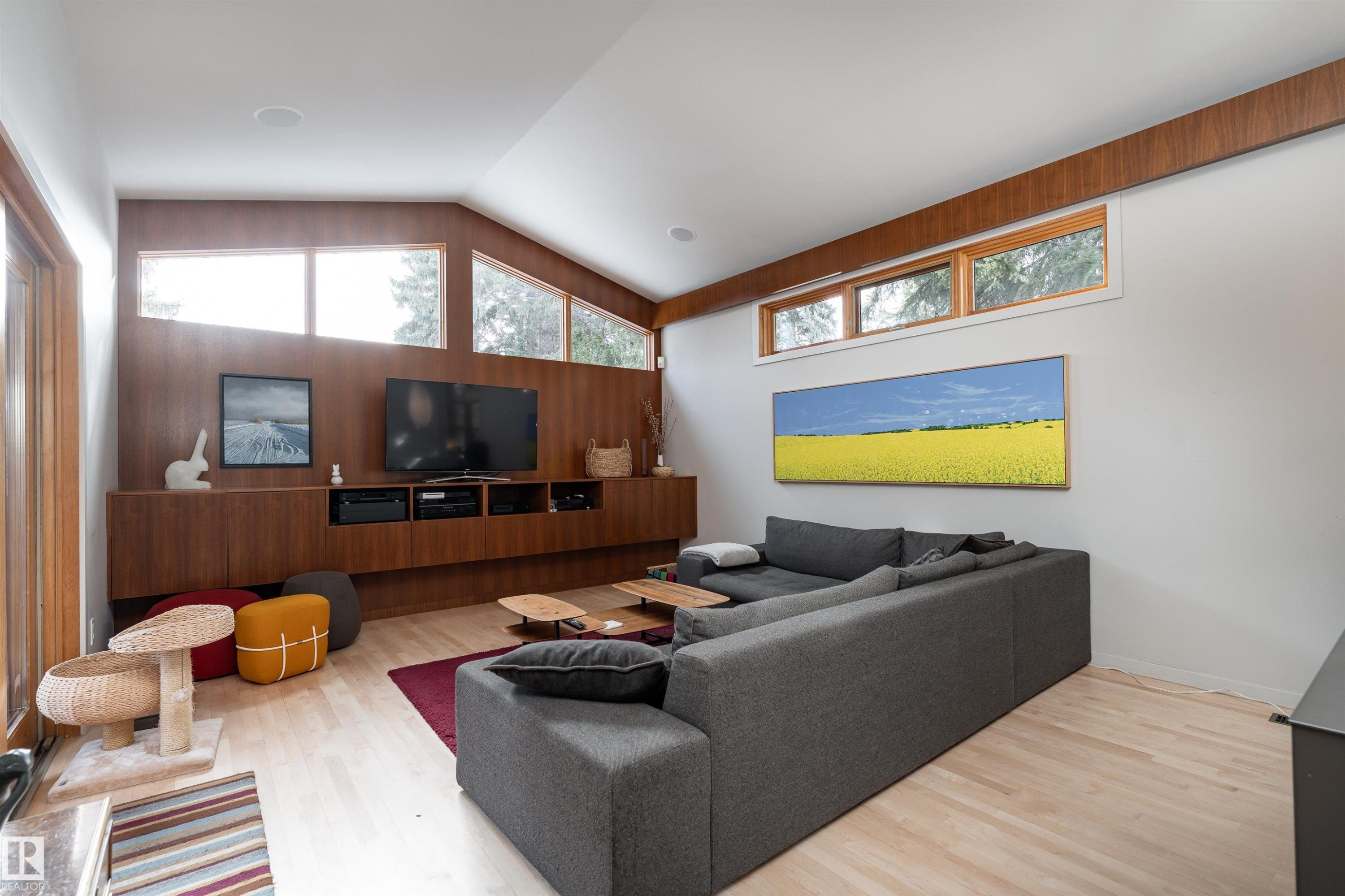 Spacious living area featuring light-toned flooring, a vaulted ceiling, and ample natural light from high windows - 9715 141 Street Nw, Edmonton, AB - Indoor Photo Showing Living Room