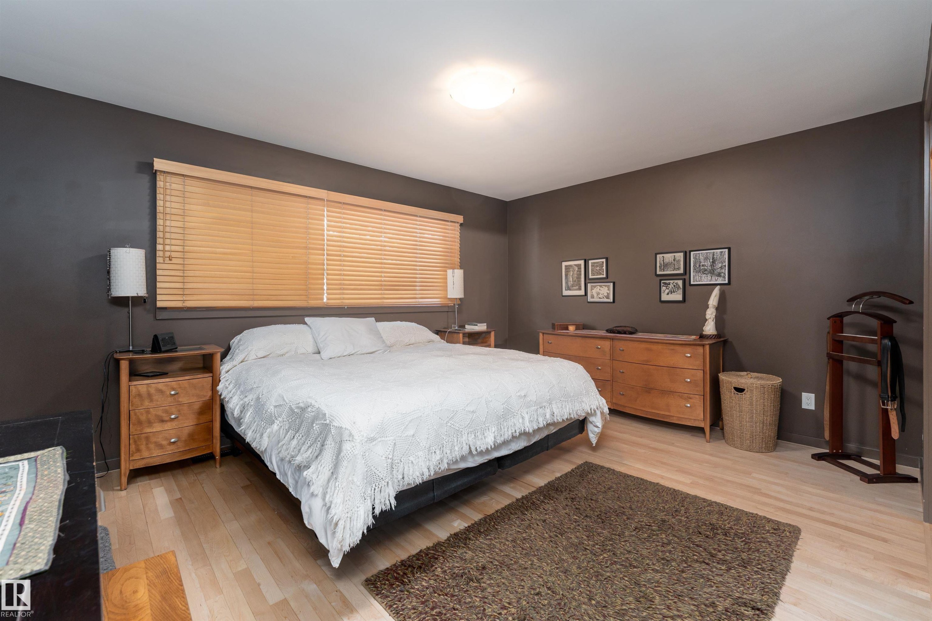 Bedroom featuring light-toned flooring, a window with blinds, and walls painted in a dark neutral tone - 9715 141 Street Nw, Edmonton, AB - Indoor Photo Showing Bedroom