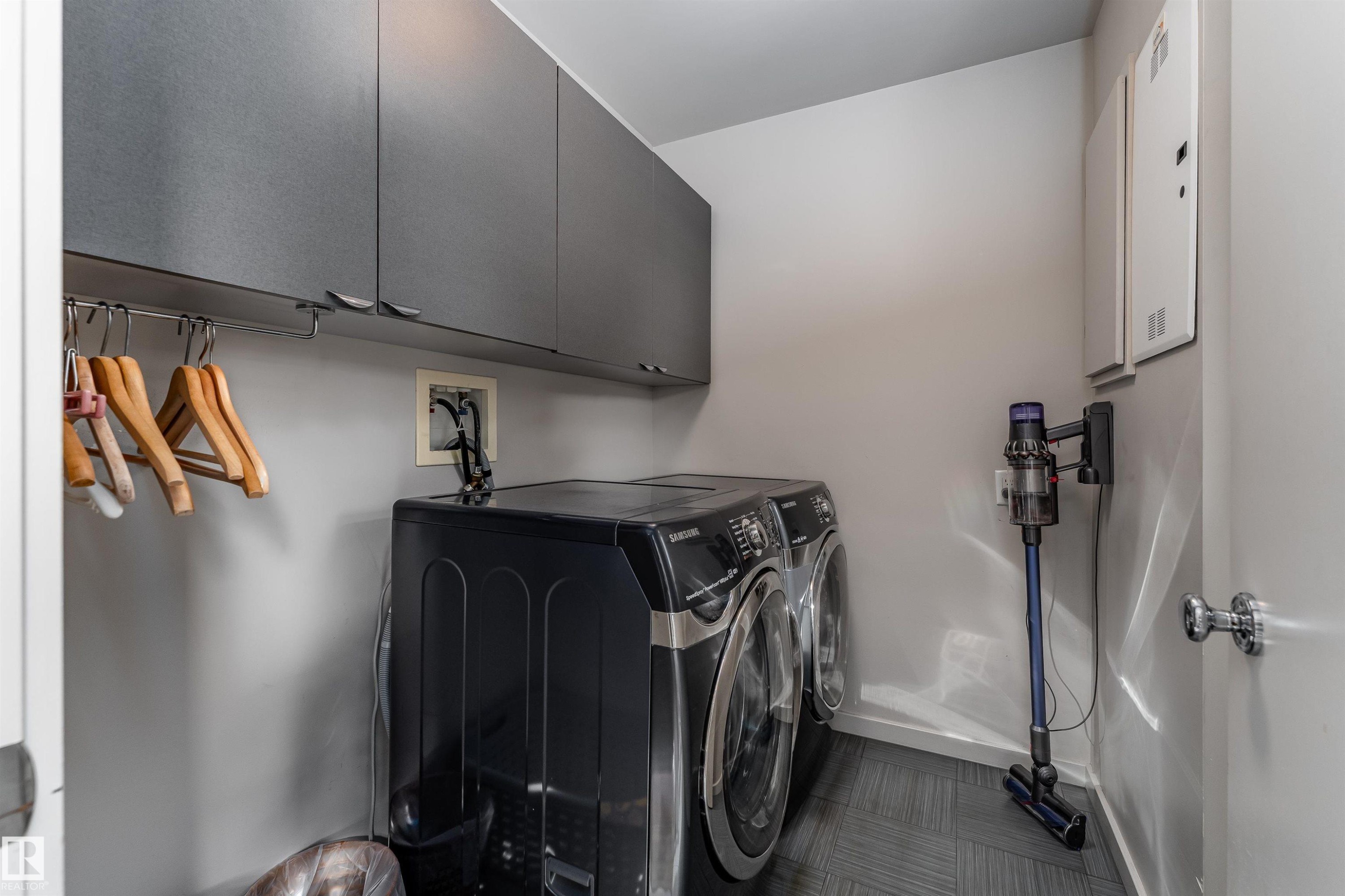 The property features a laundry area with grey cabinetry and a hanging rod - 9715 141 Street Nw, Edmonton, AB - Indoor Photo Showing Laundry Room