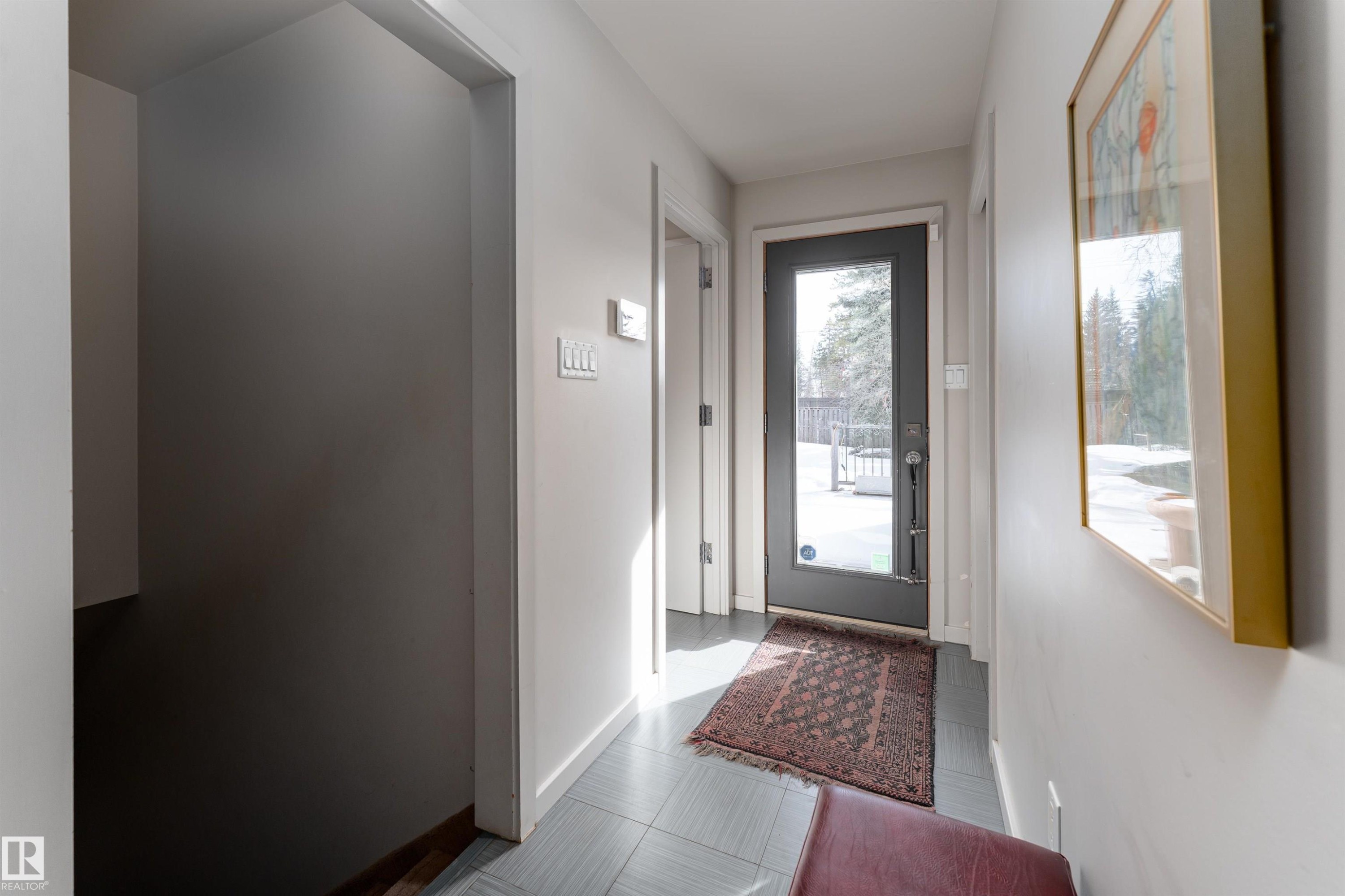 Entryway featuring light gray walls, gray tile flooring, and a glass-paneled door - 9715 141 Street Nw, Edmonton, AB - Indoor Photo Showing Other Room