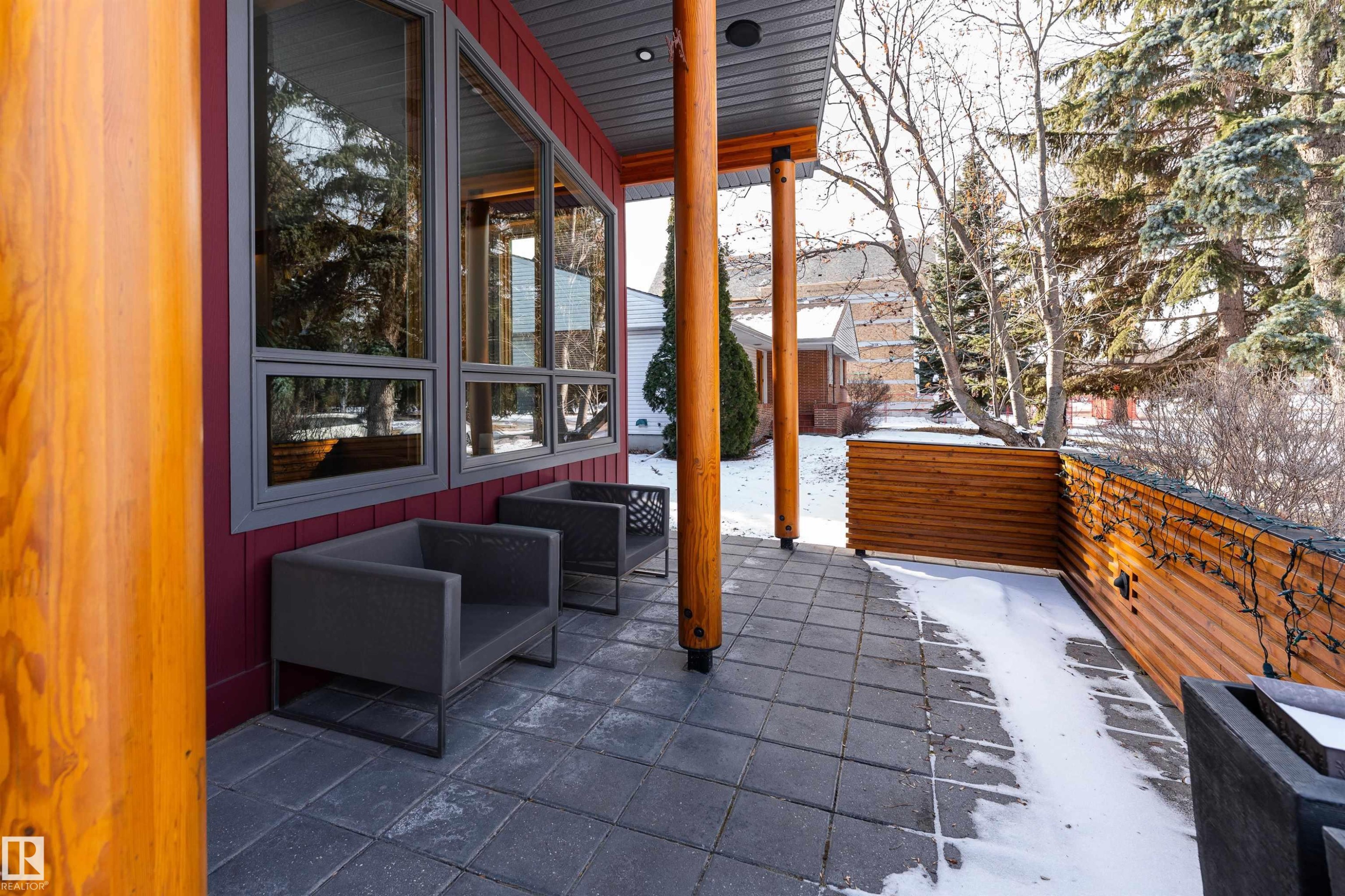 The property features an outdoor patio area with grey paver flooring and a wooden privacy screen - 9715 141 Street Nw, Edmonton, AB - Outdoor With Deck Patio Veranda With Exterior