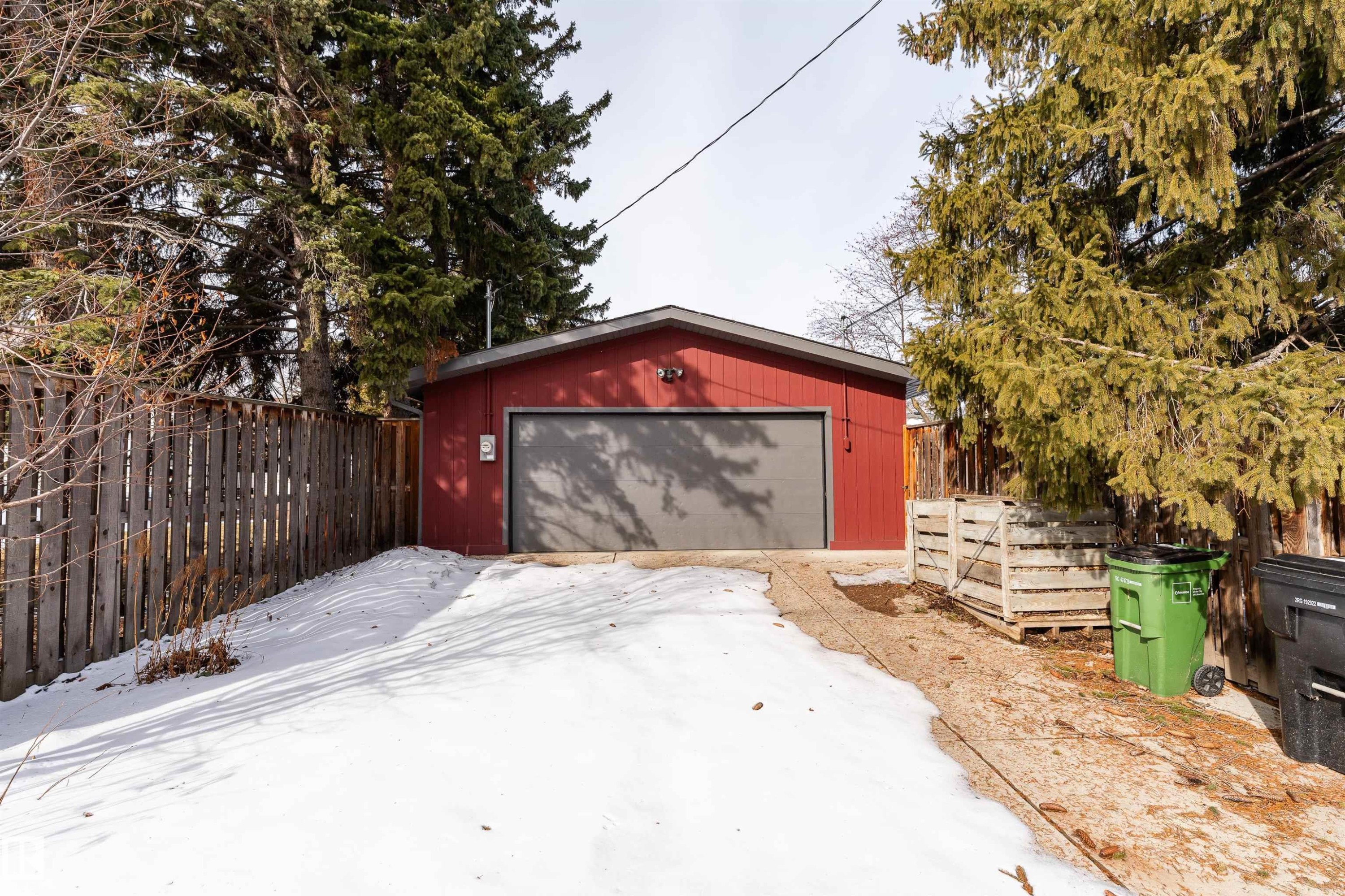 The property features a detached garage with a red exterior and a gray garage door - 9715 141 Street Nw, Edmonton, AB - Outdoor