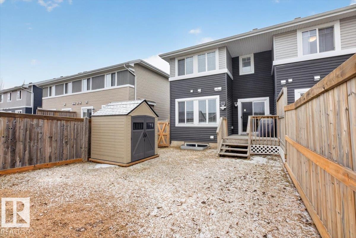 The property features a fenced backyard with a shed, a wooden deck, and a sliding glass door leading into the home - 16656 14 Avenue, Edmonton, AB - Outdoor