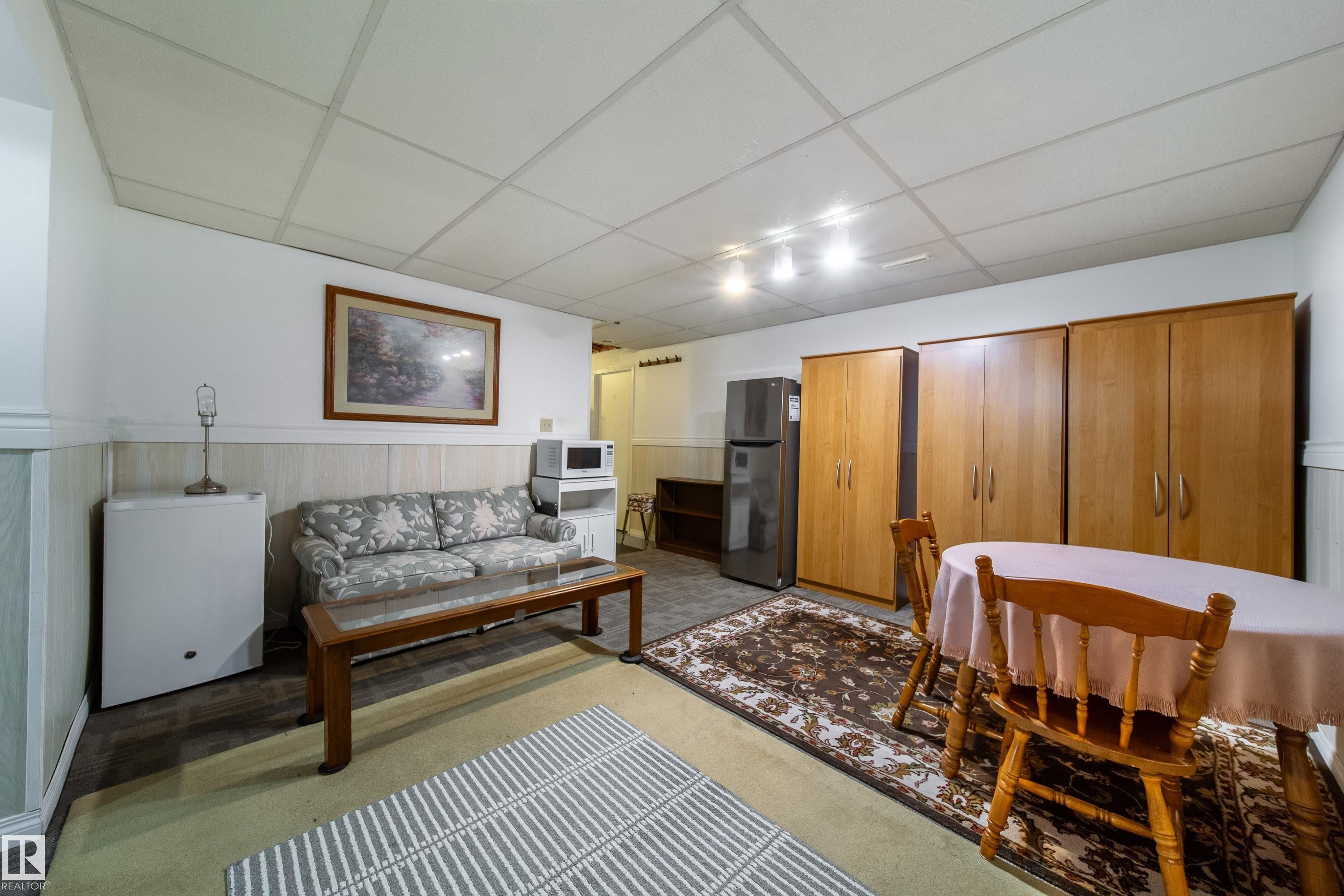 This versatile space features track lighting, a drop ceiling, and wainscoting - 1104 35 Street, Edmonton, AB - Indoor