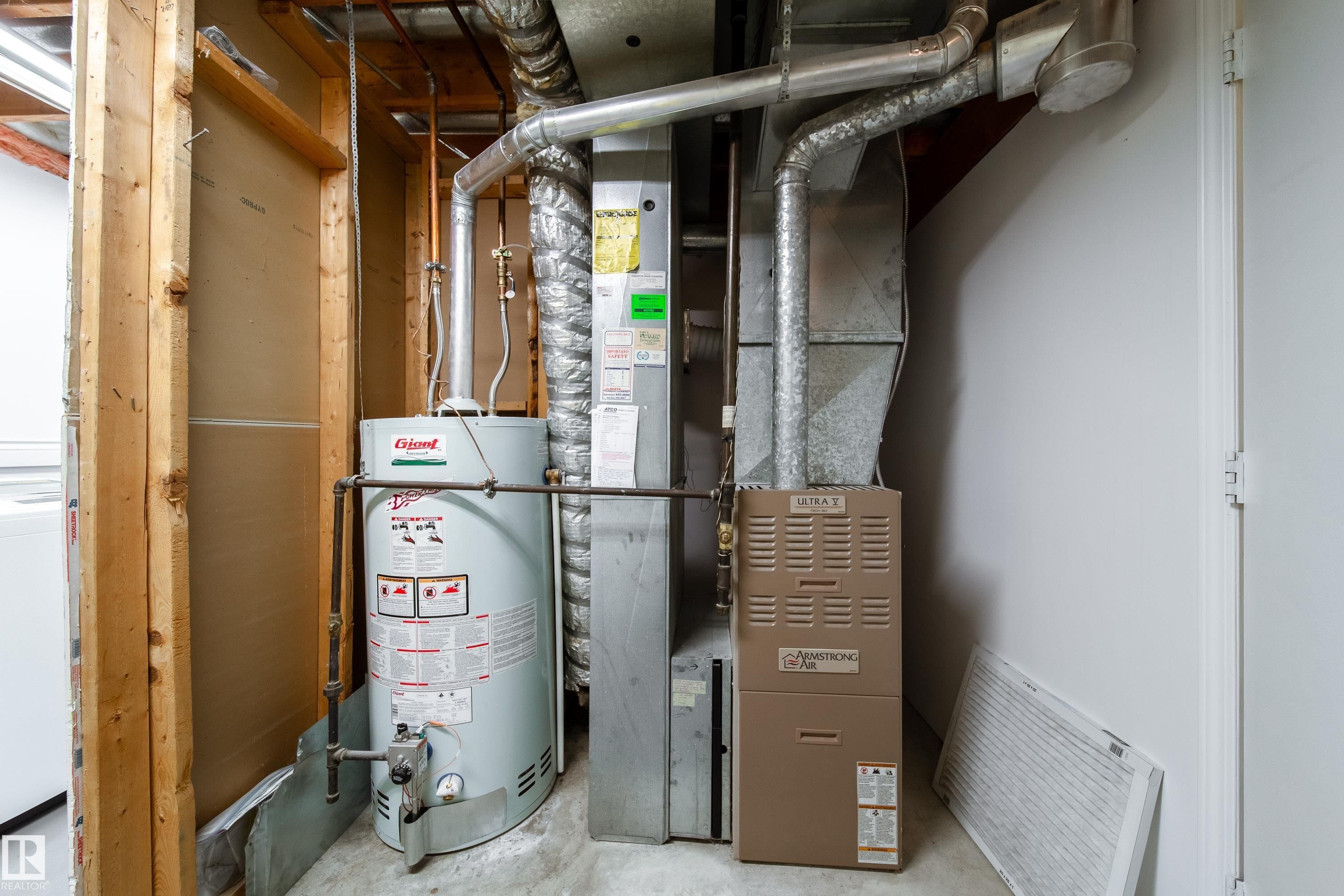 The property includes a water heater and furnace, with exposed ductwork and copper piping visible - 1104 35 Street, Edmonton, AB - Indoor Photo Showing Basement
