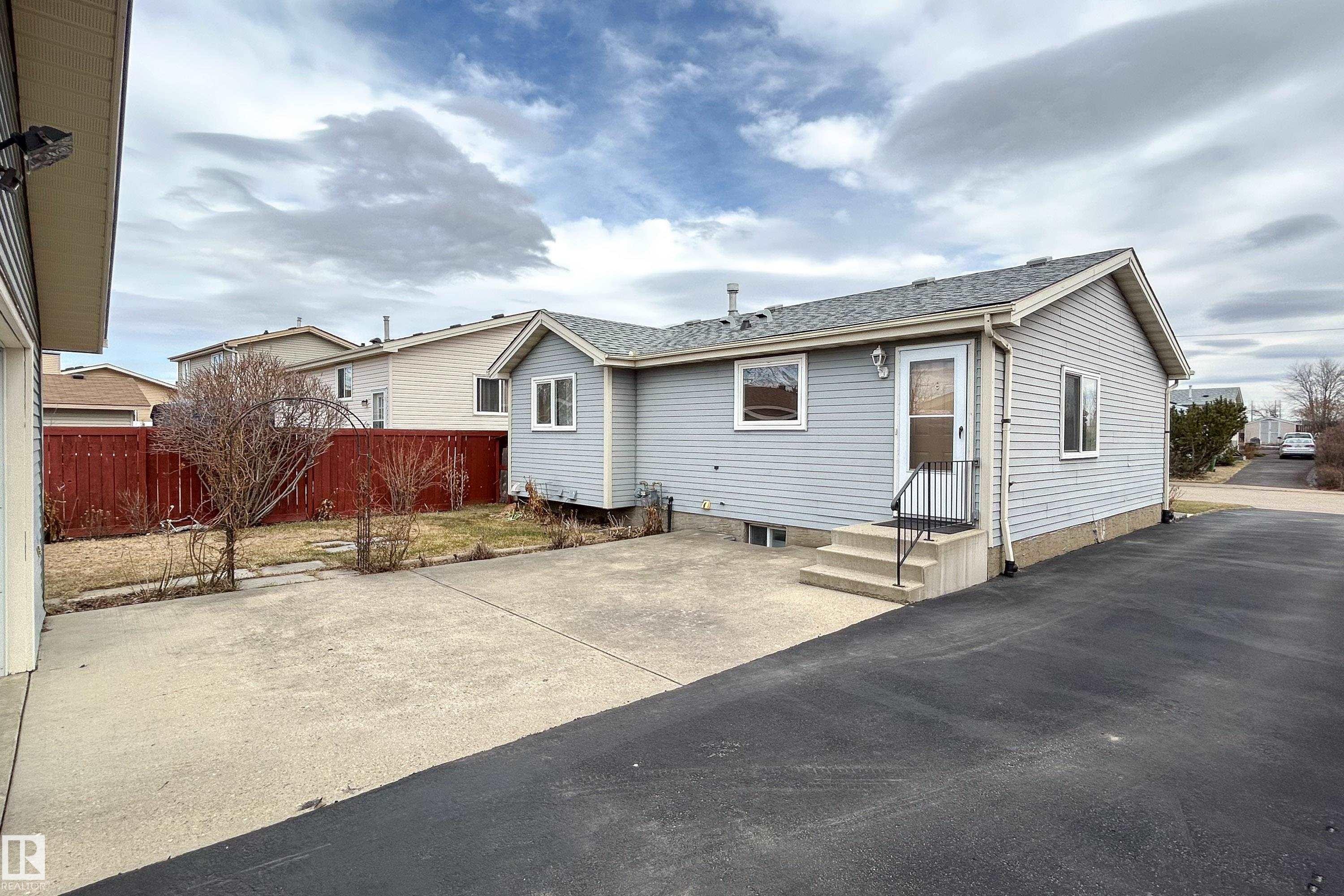 Light blue horizontal siding exterior with white window trim and a grey shingle roof - 1104 35 Street, Edmonton, AB - Outdoor