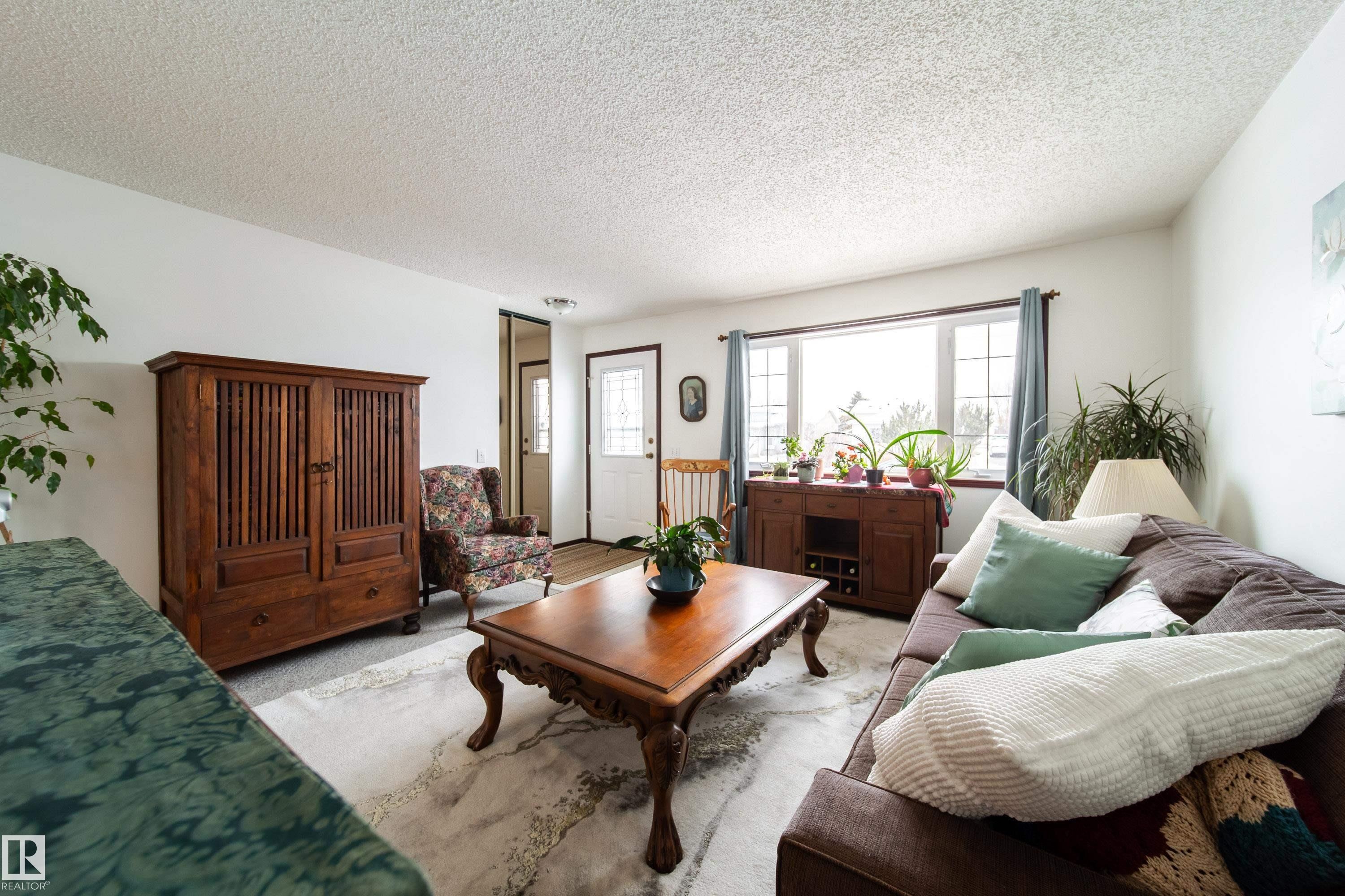 Spacious living area featuring a large window, light-colored walls, and a light-colored ceiling - 1104 35 Street, Edmonton, AB - Indoor Photo Showing Living Room