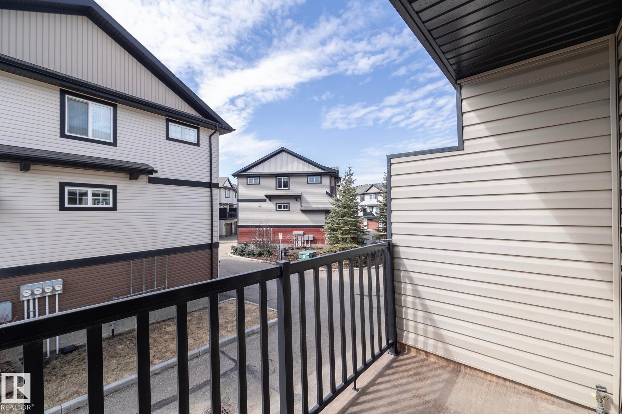 The property features a private balcony with a black metal railing, ideal for outdoor enjoyment - 1403 Cunningham Drive, Edmonton, AB - Outdoor With Exterior