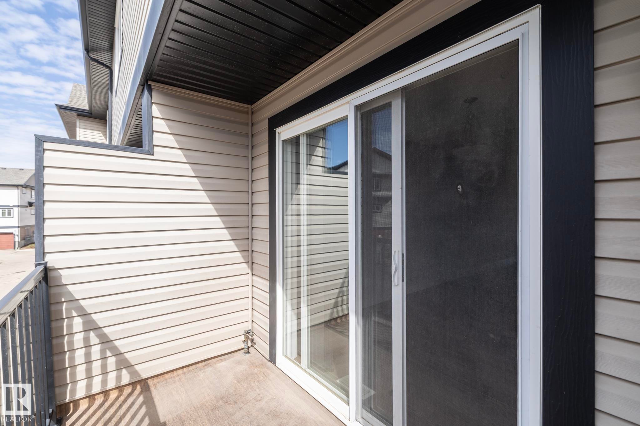 This property features a private balcony with a concrete floor, a metal railing, and light-colored siding - 1403 Cunningham Drive, Edmonton, AB - Outdoor With Exterior