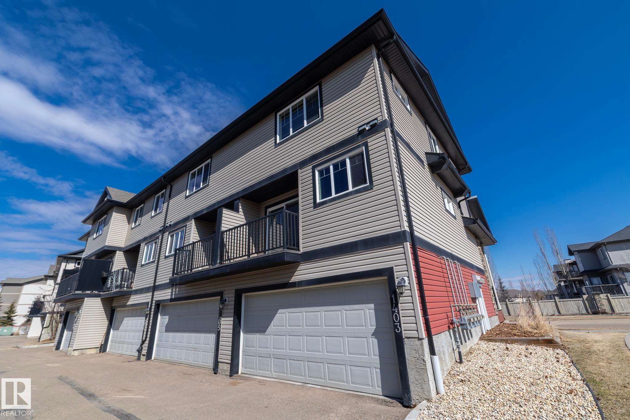 The property features a multi-story exterior with grey siding and dark trim - 1403 Cunningham Drive, Edmonton, AB - Outdoor