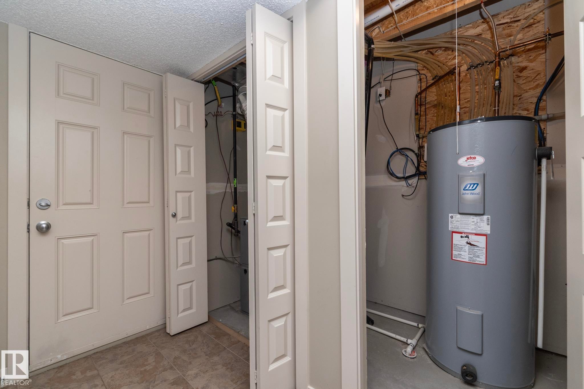 Utility area featuring a water heater and exposed ceiling joists - 1403 Cunningham Drive, Edmonton, AB - Indoor Photo Showing Basement