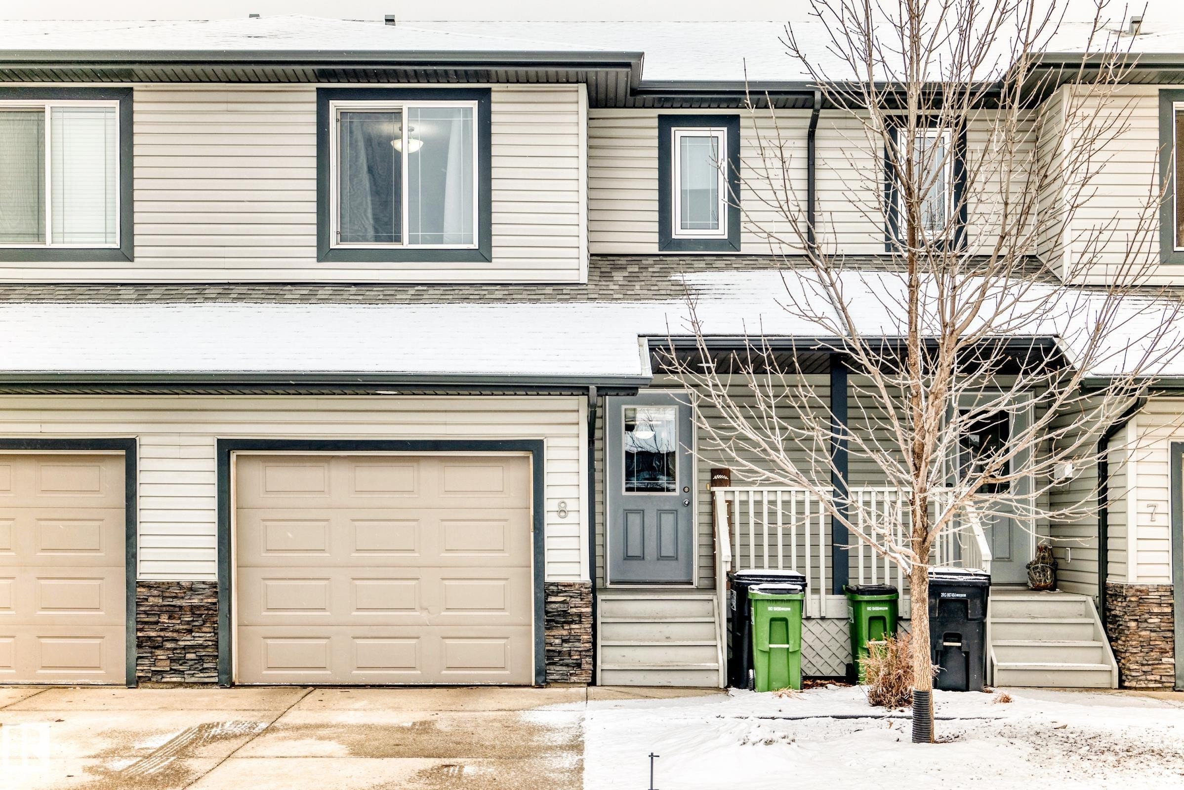 The property features a multi-level exterior with light-colored siding, dark trim, and stone accents - 8 13838 166Ave, Edmonton, AB - Outdoor