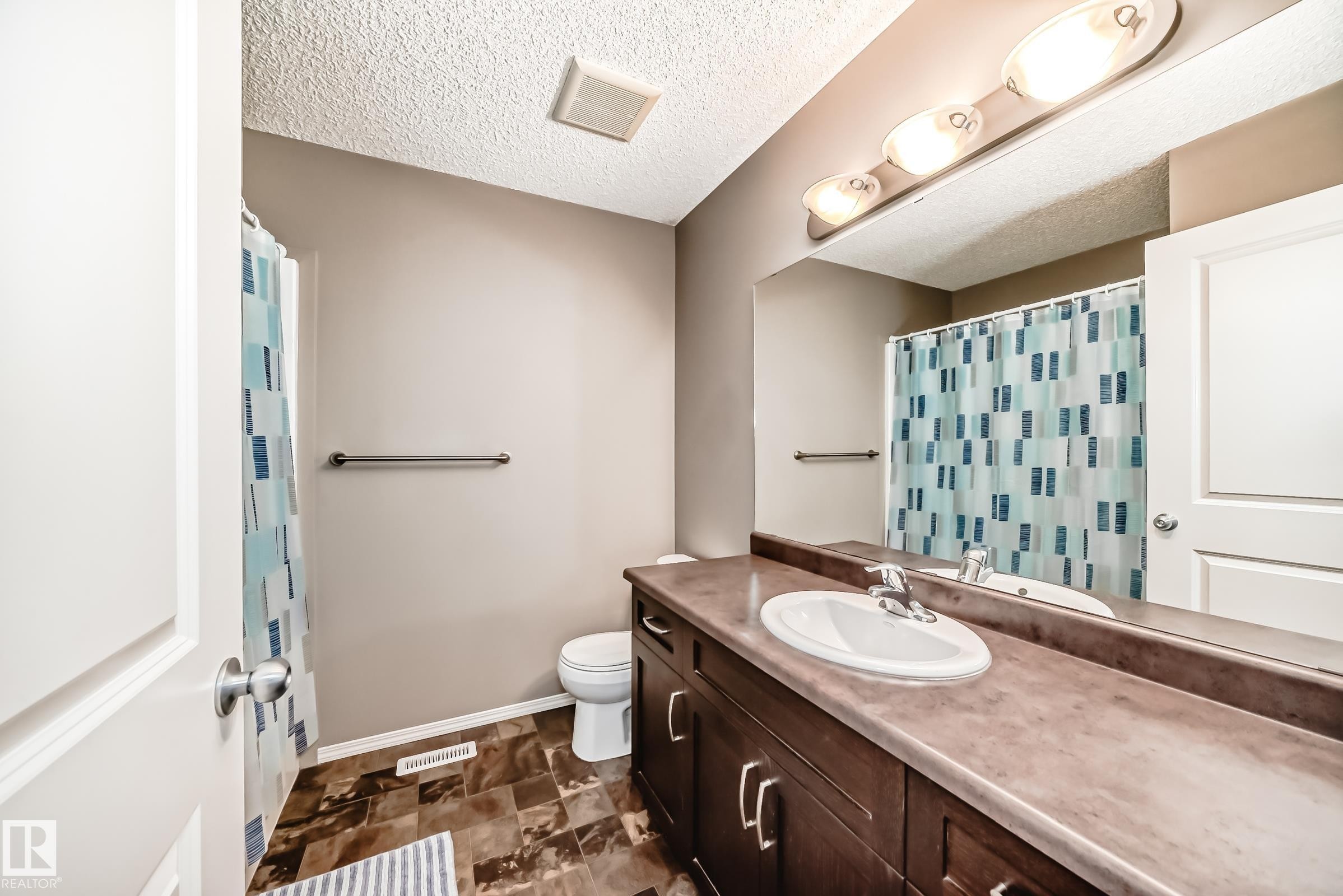 The bathroom features a vanity with a sink, a mirror, and overhead lighting - 8 13838 166Ave, Edmonton, AB - Indoor Photo Showing Bathroom