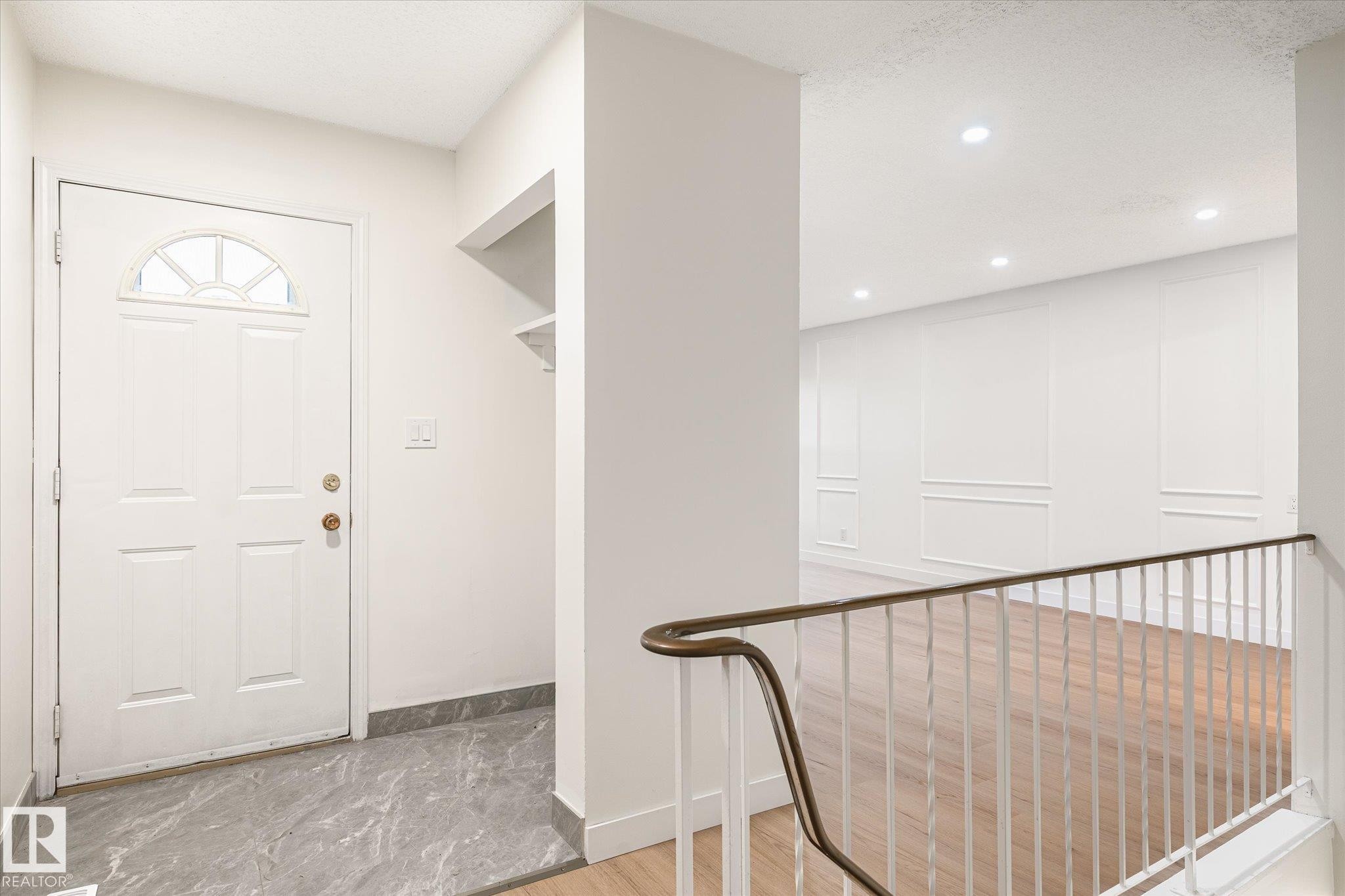 Entryway featuring a white door with an arched window, grey tiled flooring, and a built-in shelf - 6540 184 Street, Edmonton, AB - Indoor Photo Showing Other Room