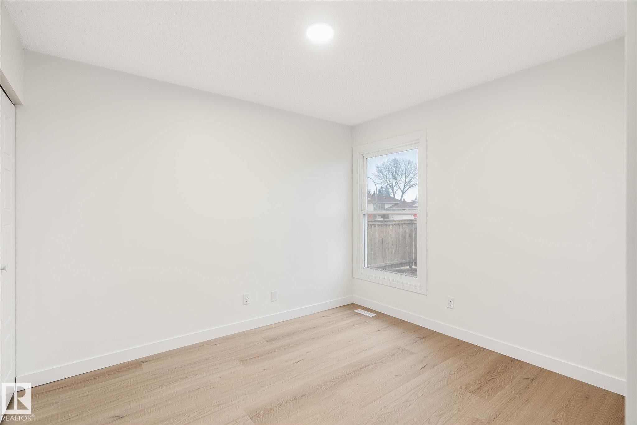 This inviting room features light-colored walls, light wood flooring, and a window providing natural light - 6540 184 Street, Edmonton, AB - Indoor Photo Showing Other Room