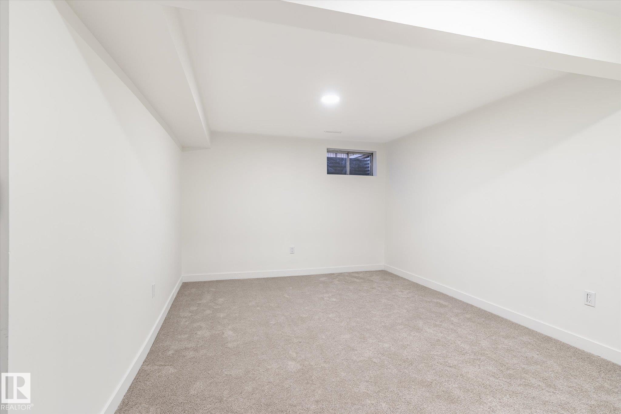 This room features plush grey carpeting, white walls, and a window providing natural light - 6540 184 Street, Edmonton, AB - Indoor Photo Showing Other Room